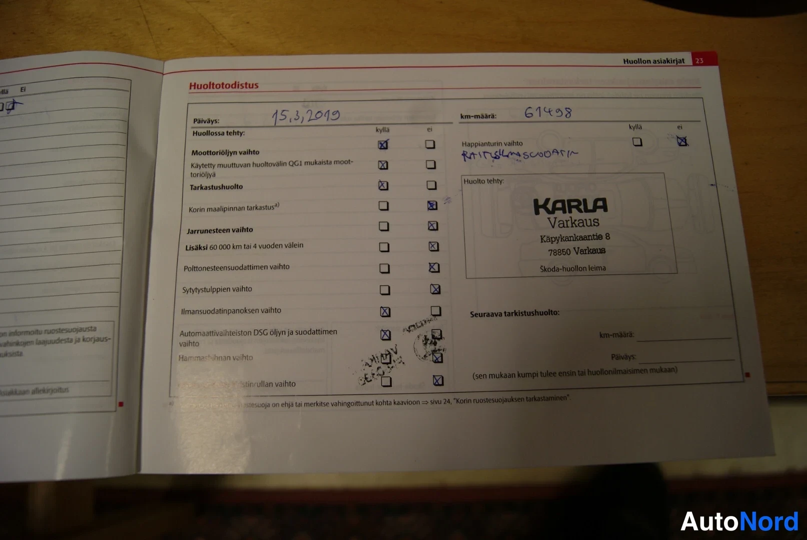 Asiakirja: A scanned page of a service book (Huoltotodistus), showing a stamped entry dated 15.3.2019 with mileage 61498 km, signed off by Karla Varkaus Skoda service cent