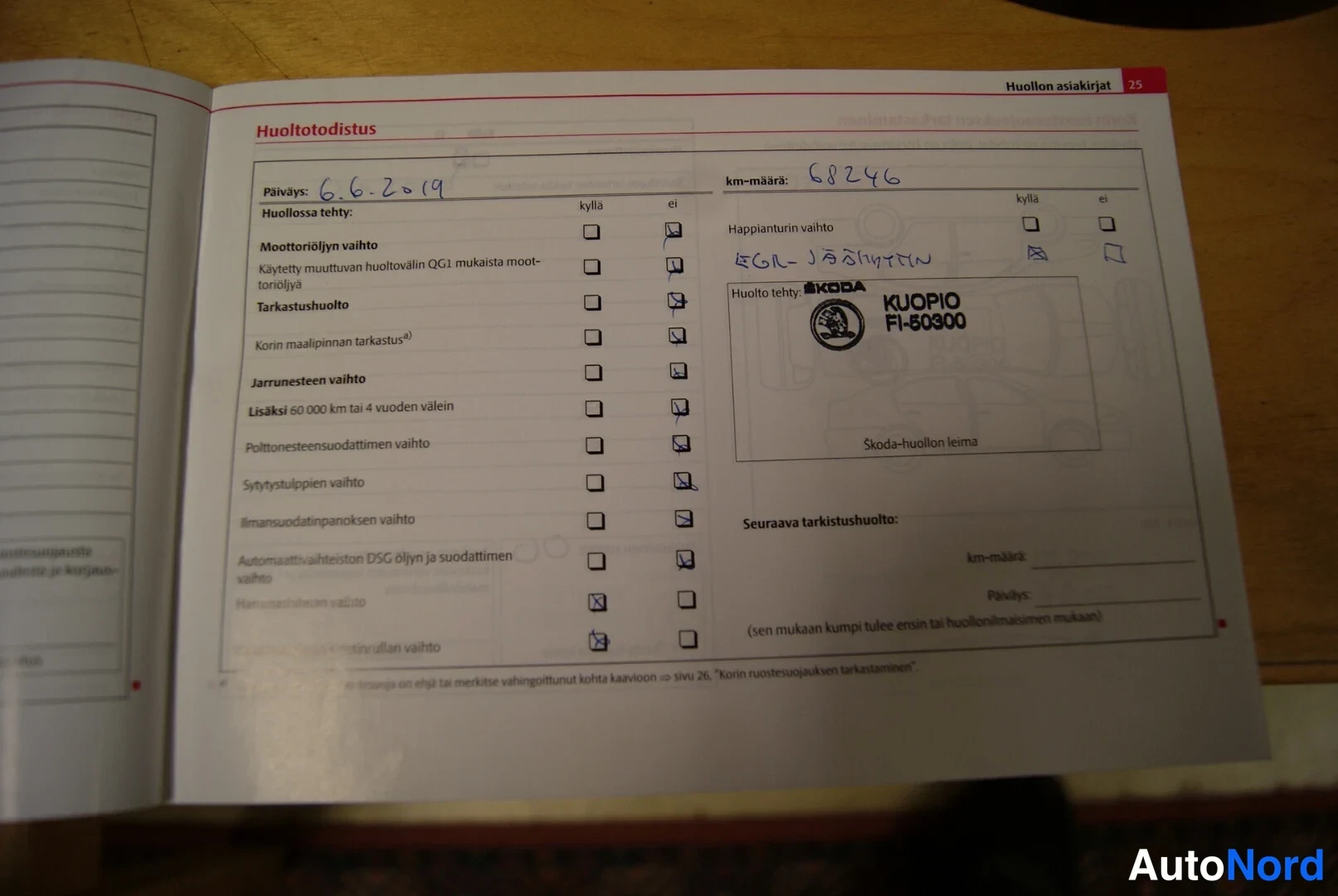 Muu: Avattu huoltokirja: Huoltotodistus-sivu, käsin kirjattu päiväys 6.6.2019 ja km-määrä 68246, Skoda-huollon leima KUOPIO FI-60300.