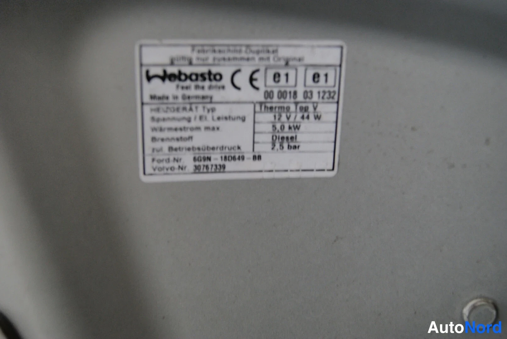 Edestä: Webasto-lämmityslaitteen tyyppikilpi: Thermo Top V, 12 V / 44 W, Diesel.