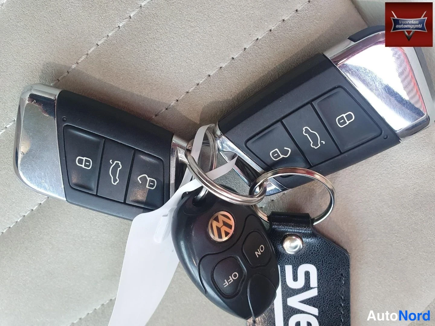 Yksityiskohta: Kaksi Volkswagen-avainkaluston avainta ja kauko-ohjain avainnipussa, SVE-tekstinen avainperä.