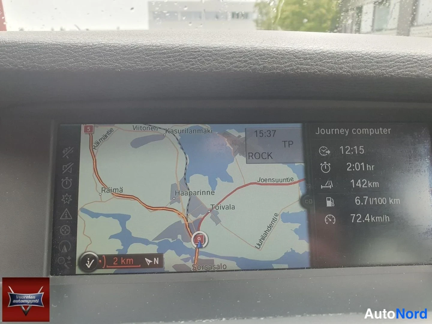 Yksityiskohta: Autoon sisäänrakennetun navigointijärjestelmän näyttö: kartta reitistä sekä Journey computer -tiedot (aika 12:15, kesto 2:01 h, matka 142 km, kulutus 6,7 l/100