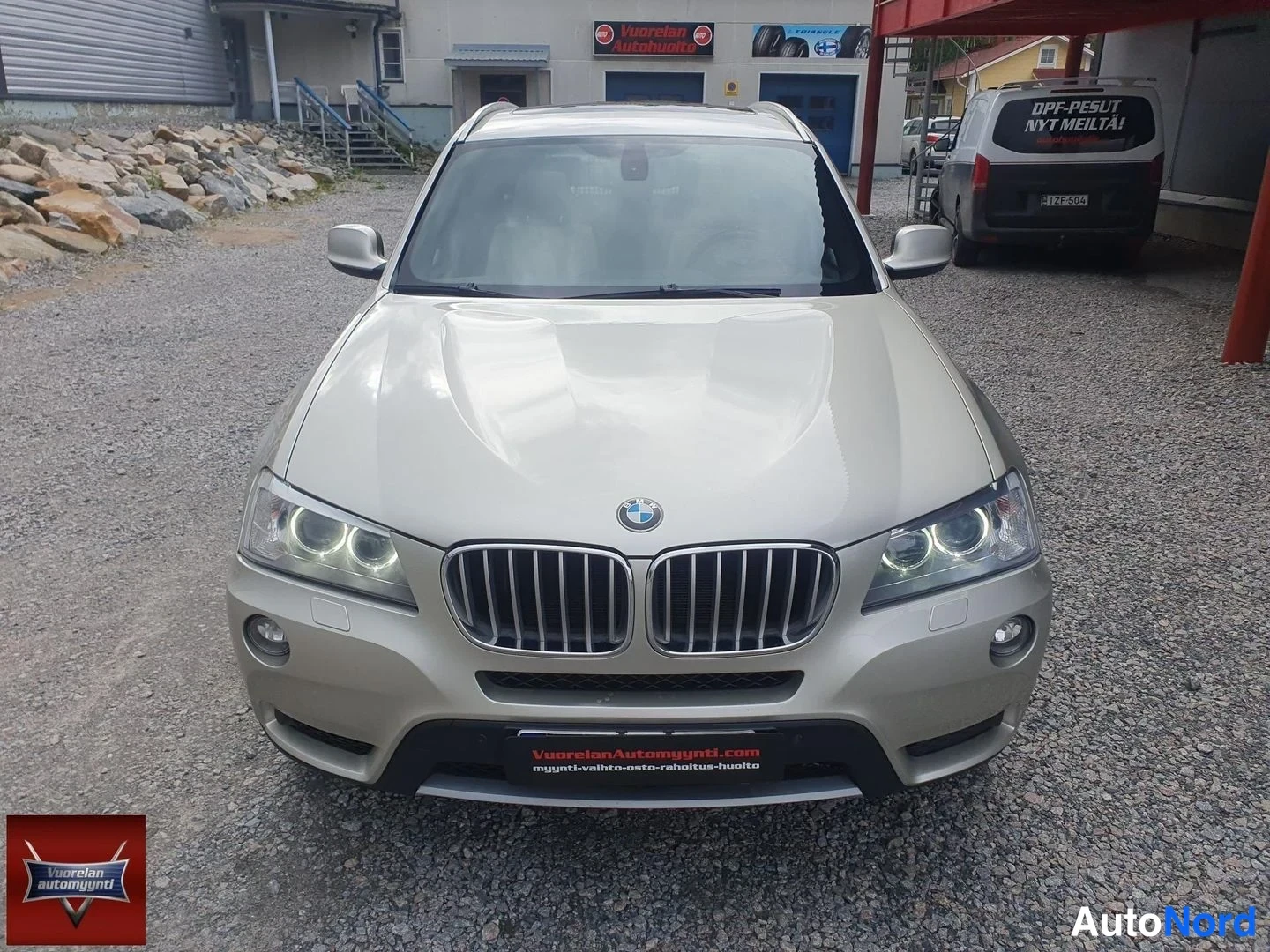 Edestä: Auton etupää suoraan edestä valokuvattuna: beige-kultainen kori, BMW-merkki munuaissäleikössä ja LED-turvalamput.