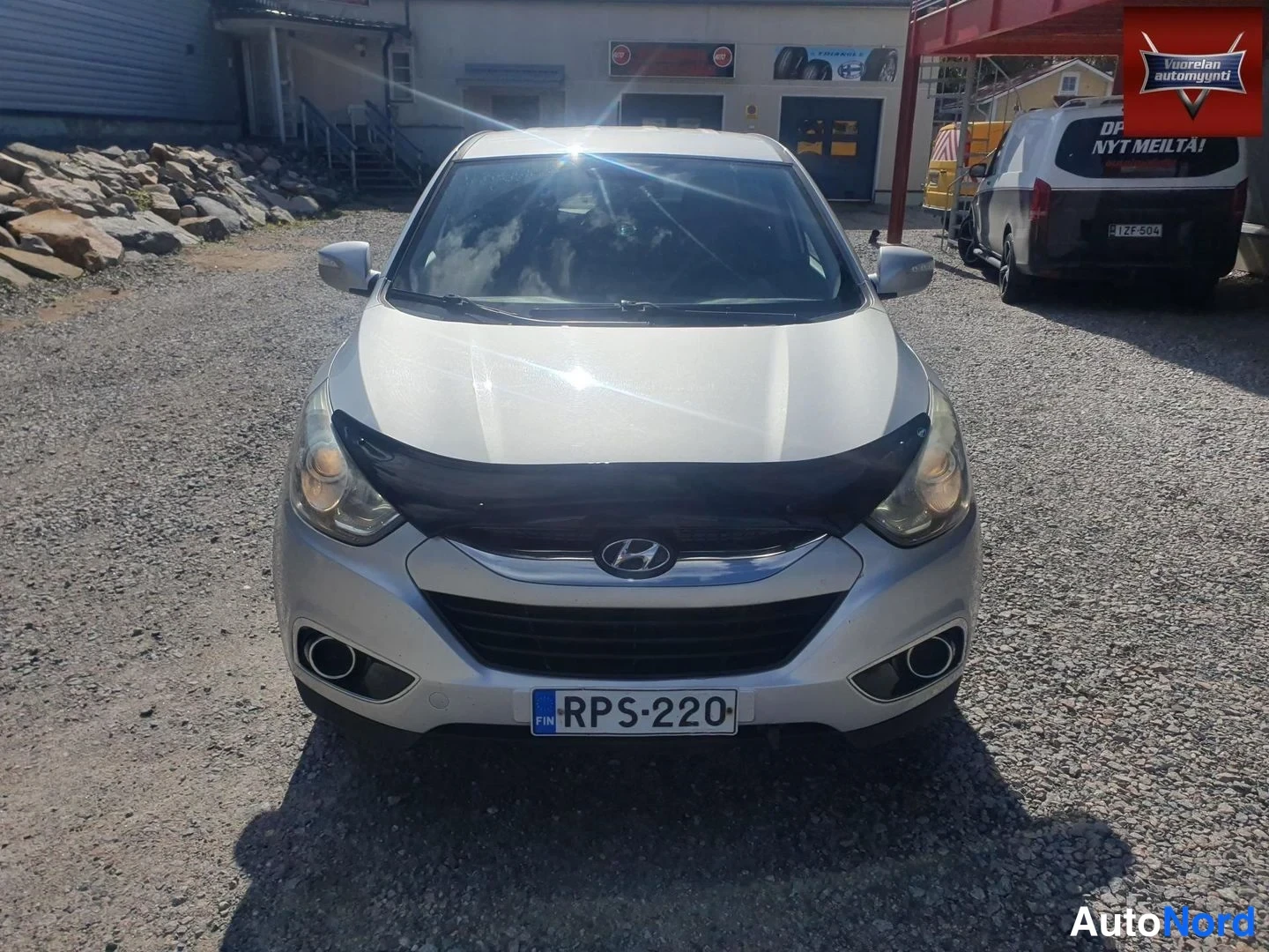 Edestä: Hyundai ix35 suoraan edestä kuvattuna, rekisterikilpi, auringon heijastus tuulilasissa.