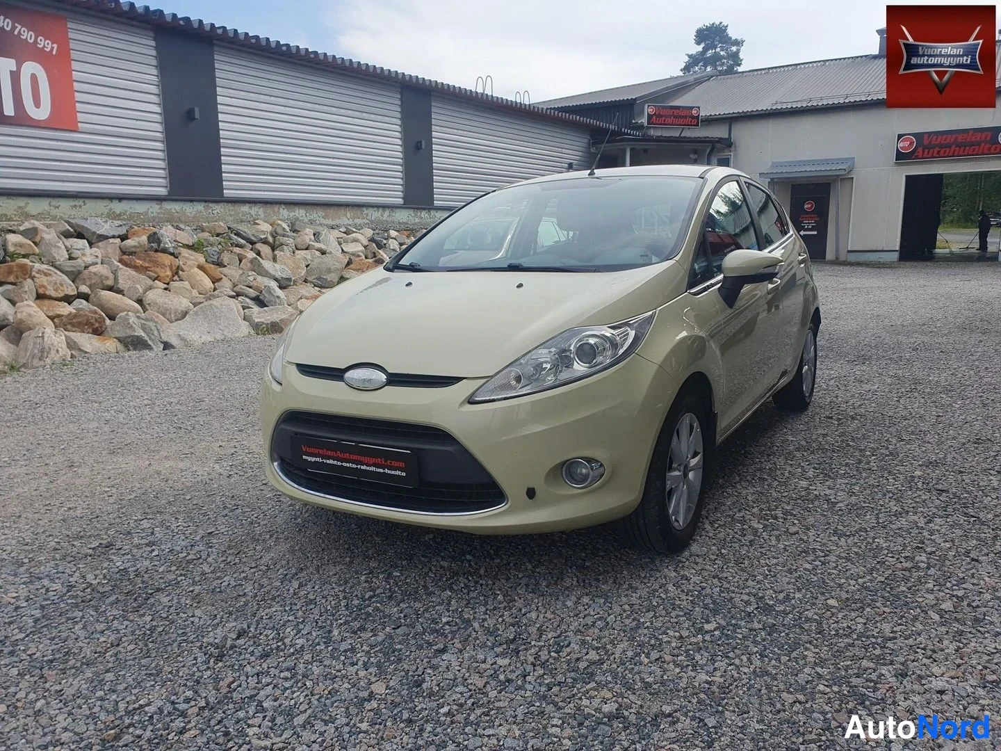 Etuviisto, nokka vasemmalle: Beige lavanvärinen viisiovinen hatchback etu kolmasosa vasemmalta, etusäleikkö ja ajovalot näkyvät.