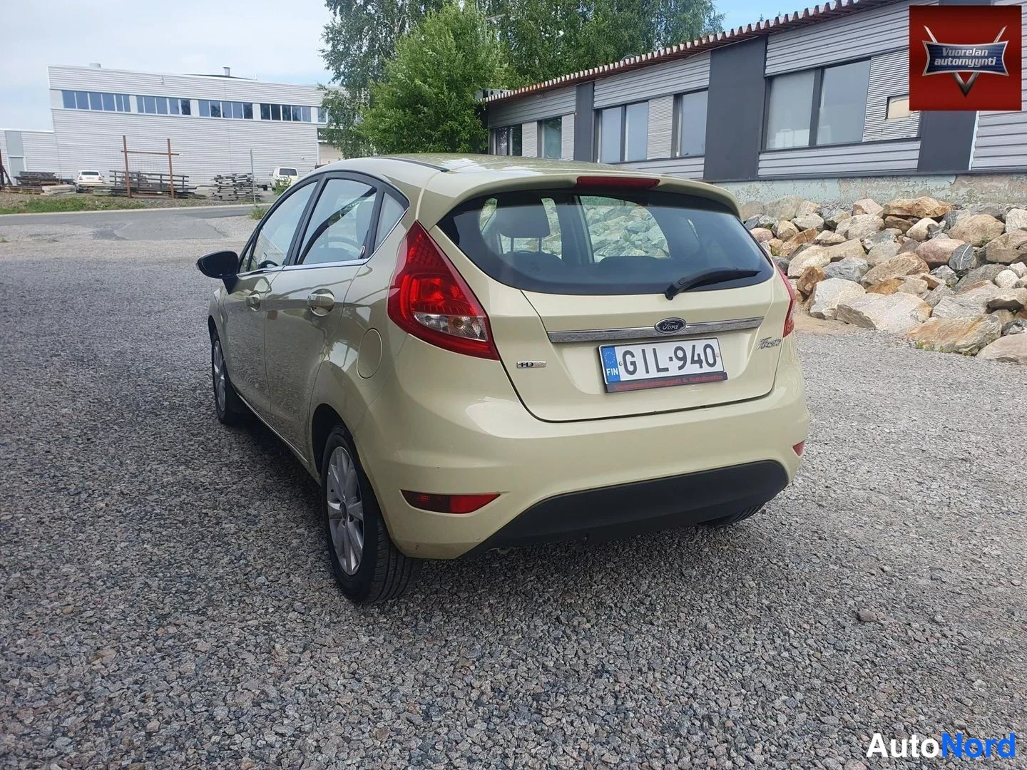 Takaviisto: Beige lavanvärinen hatchback taka kolmasosa vasemmalta, rekisterikilpi.