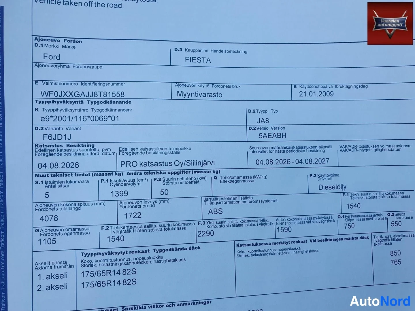 Asiakirja: Close-up photograph of a blue vehicle registration and inspection document for a Ford Fiesta.