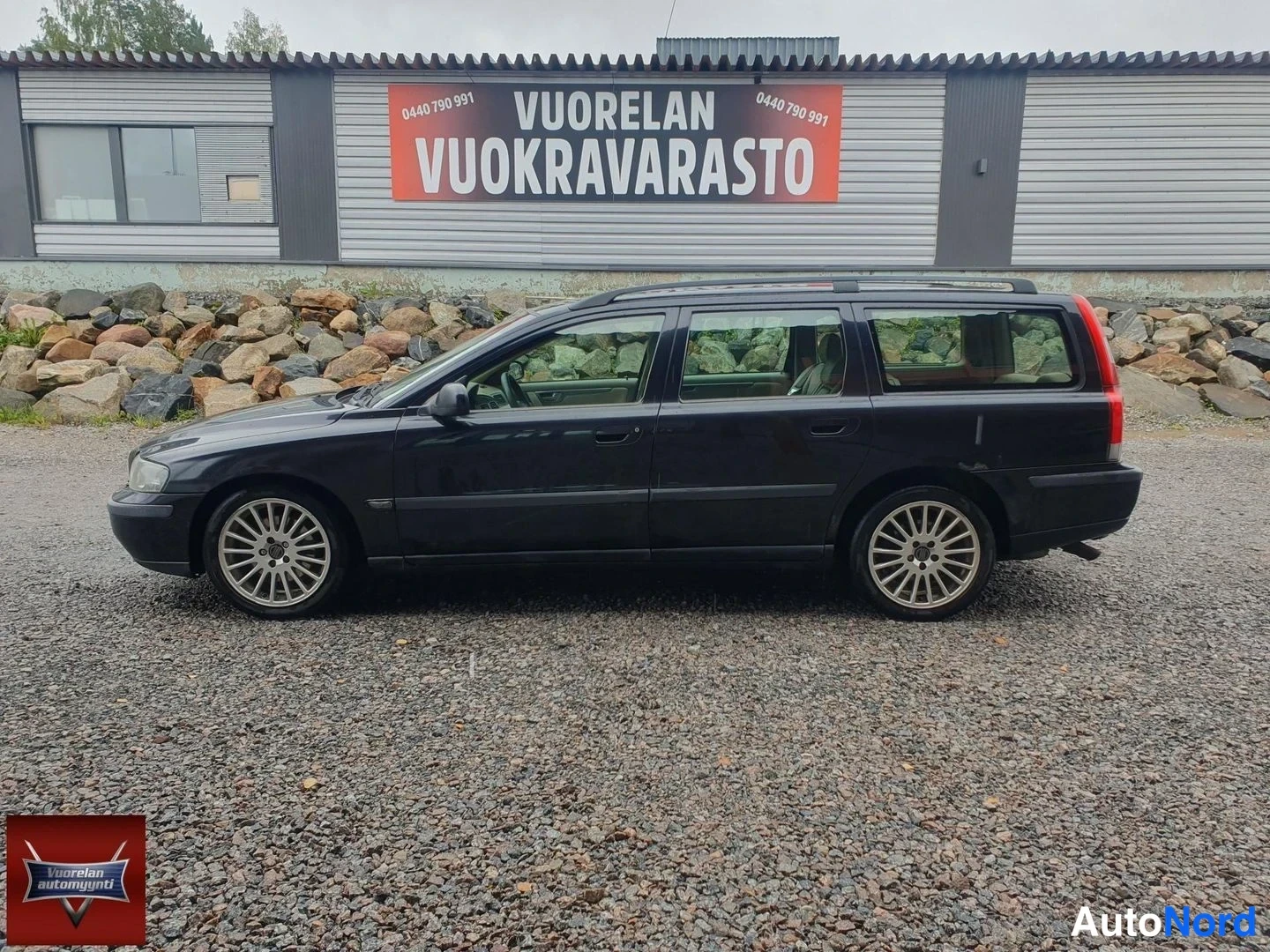 Sivulta: Musta farmariauto sivusta kuvattuna; kattokaiteet ja moniokkaiset alumiinivanteet näkyvissä.