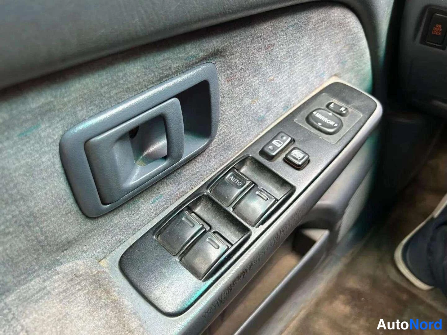 Muu: Oven sisäpaneelin ikkunonnostokytkimet ja peilinsäädin, yksi kytkimistä merkitty AUTO.