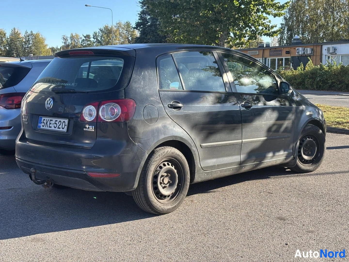 Takaviisto: Tummanvärisen viisiovisen auton takakolmiveto kuvattuna vasemmalta; rekisterikilpi ja TSI-merkki takaluukussa, pyyhkijälviki takaluukun takaikkunassa.