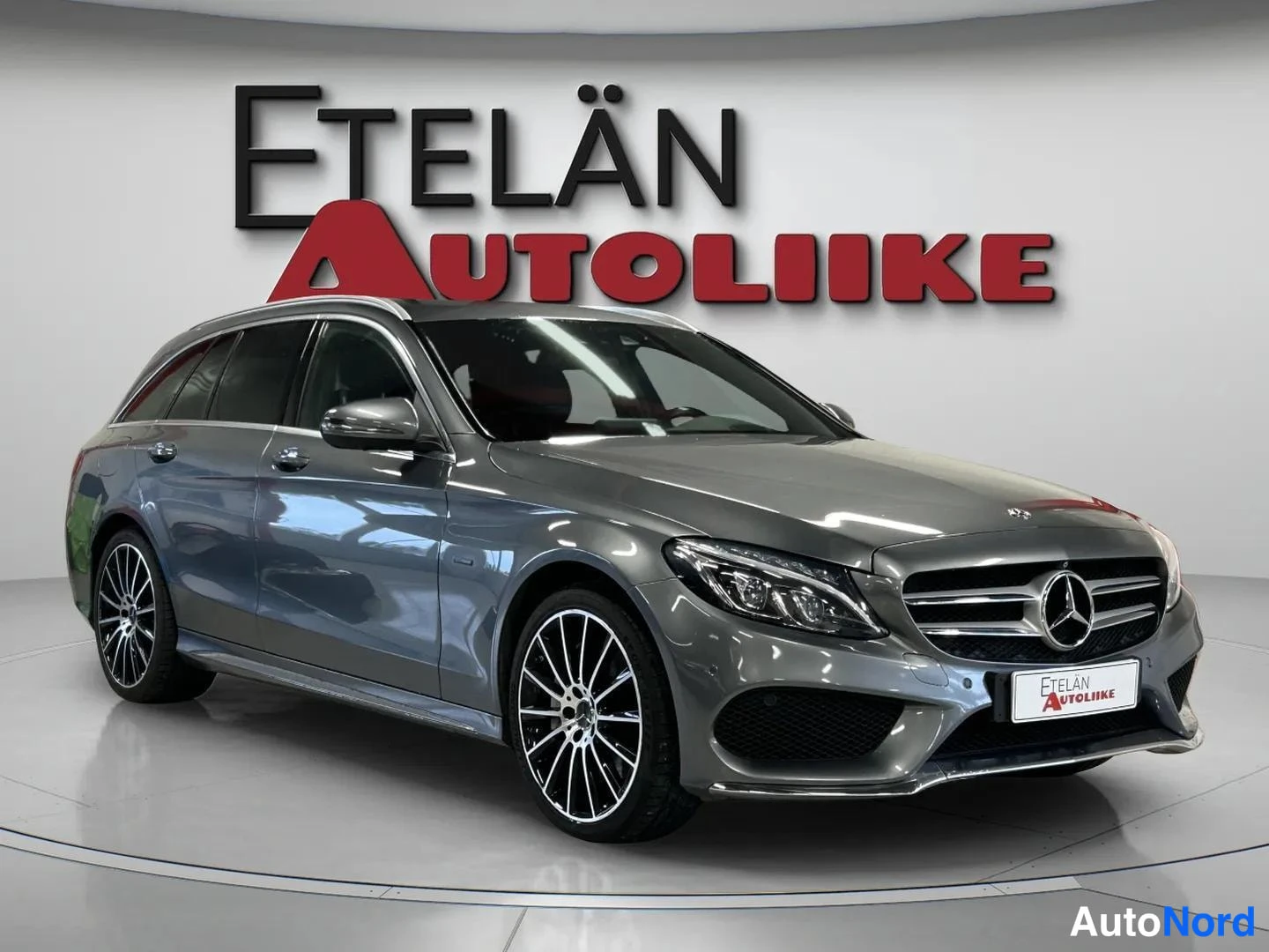 Etuviisto, nokka oikealle: Harmaa Mercedes-Benz C-luokan farmari kuvattu etukulmasta oikealta studiovalossa.