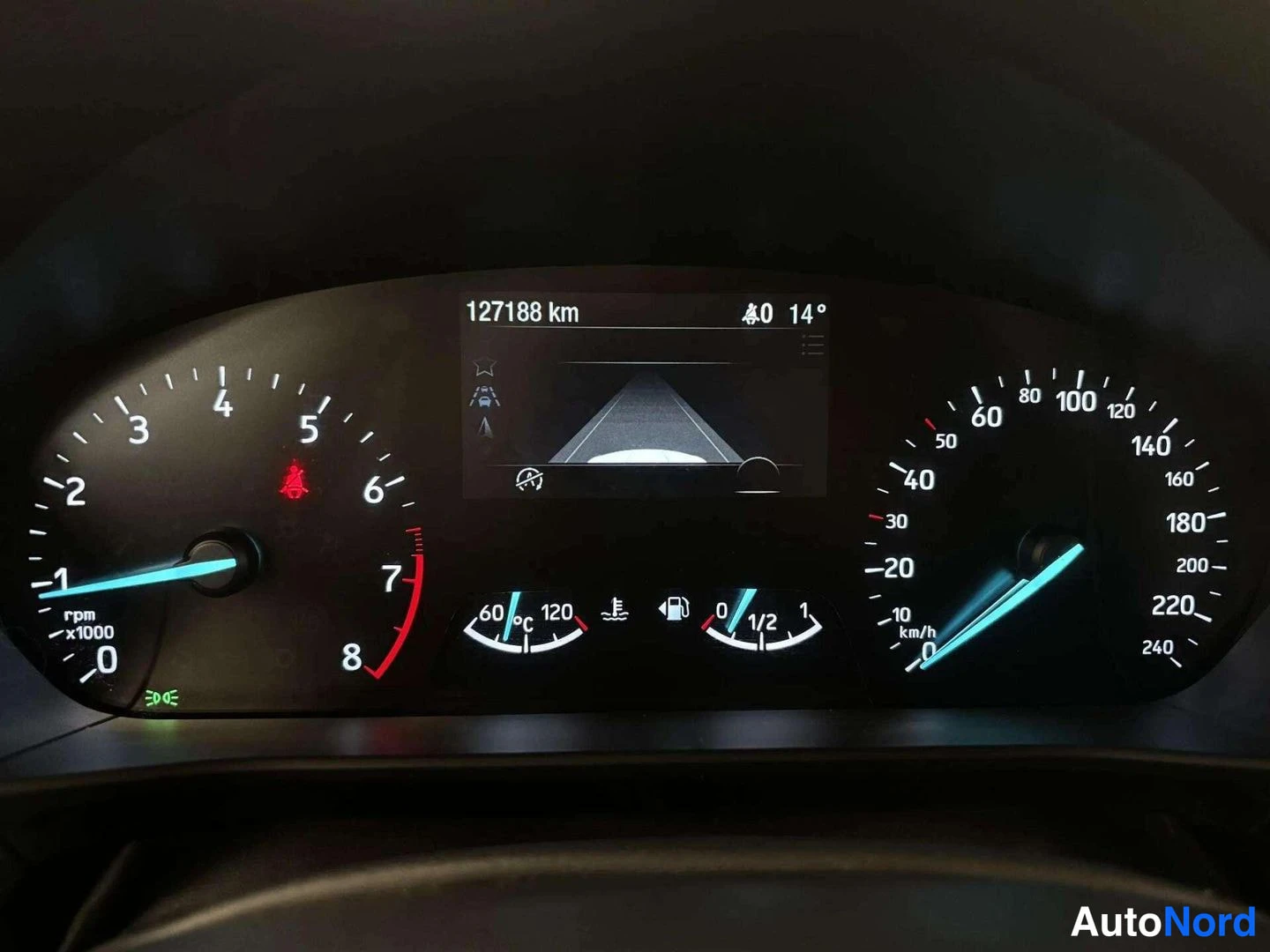 Muu: Kojelaudan mittaristo näytöllä lukema 127188 km, nopeusmittari asteikolla 0–240 km/h ja kierrosmittari 0–8.