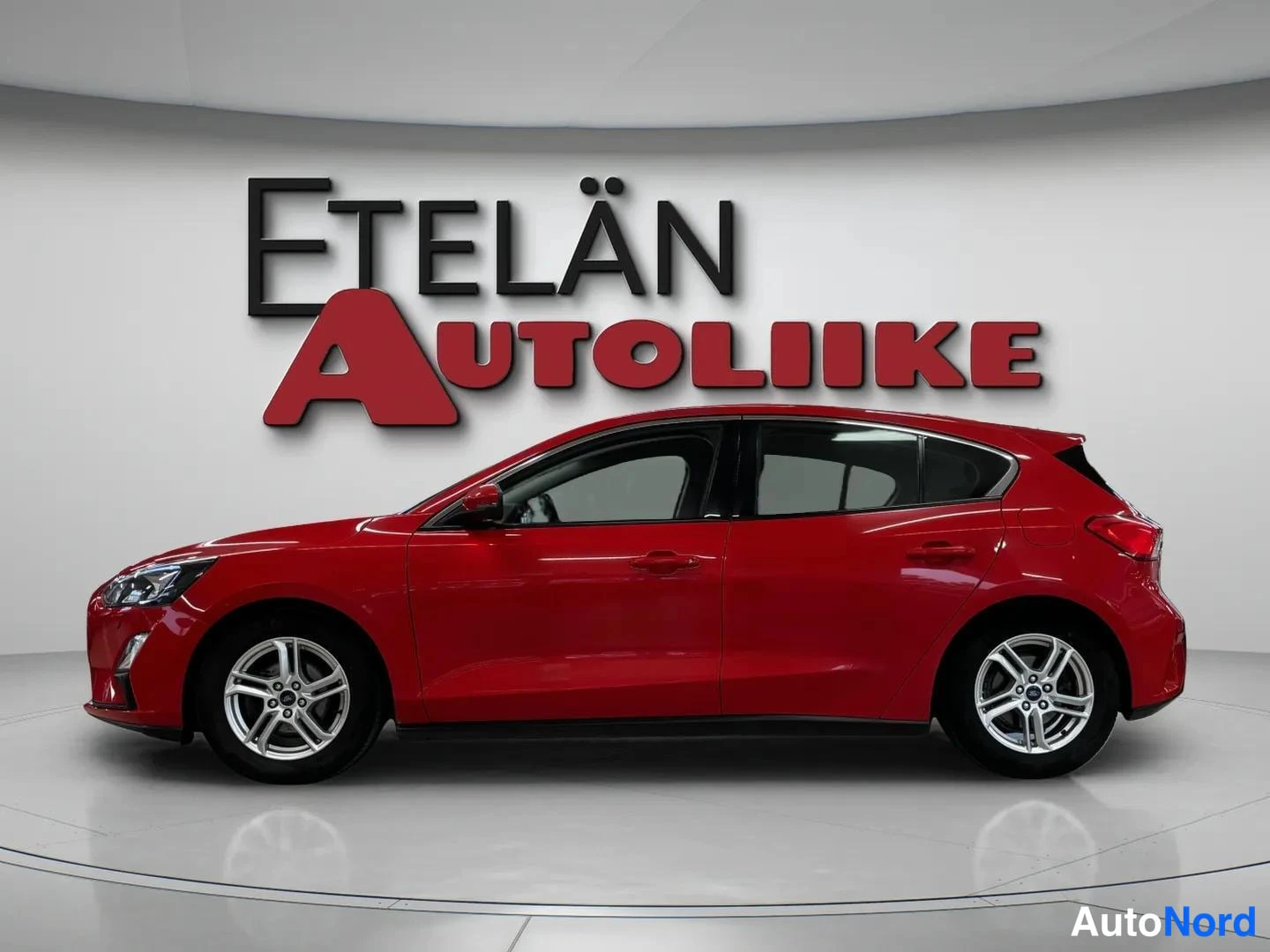 Etuviisto, nokka vasemmalle: Punainen automobiili sivulta hieman edestä kuvattuna, Etelän Autoliike -logo taustalla.
