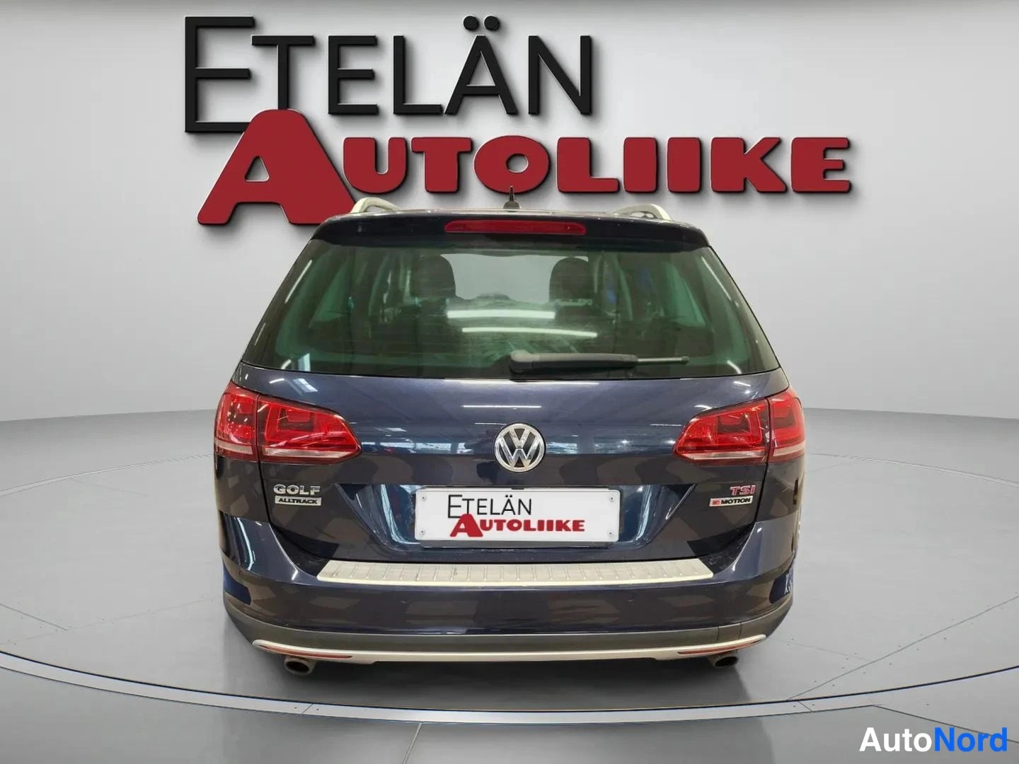 Takaa: Volkswagen Golfin takaosa takaa kuvattuna, sinertävän tumma korinpäälline, punaiset takavalot ja takapuskuri; hallin logo näkyvissä