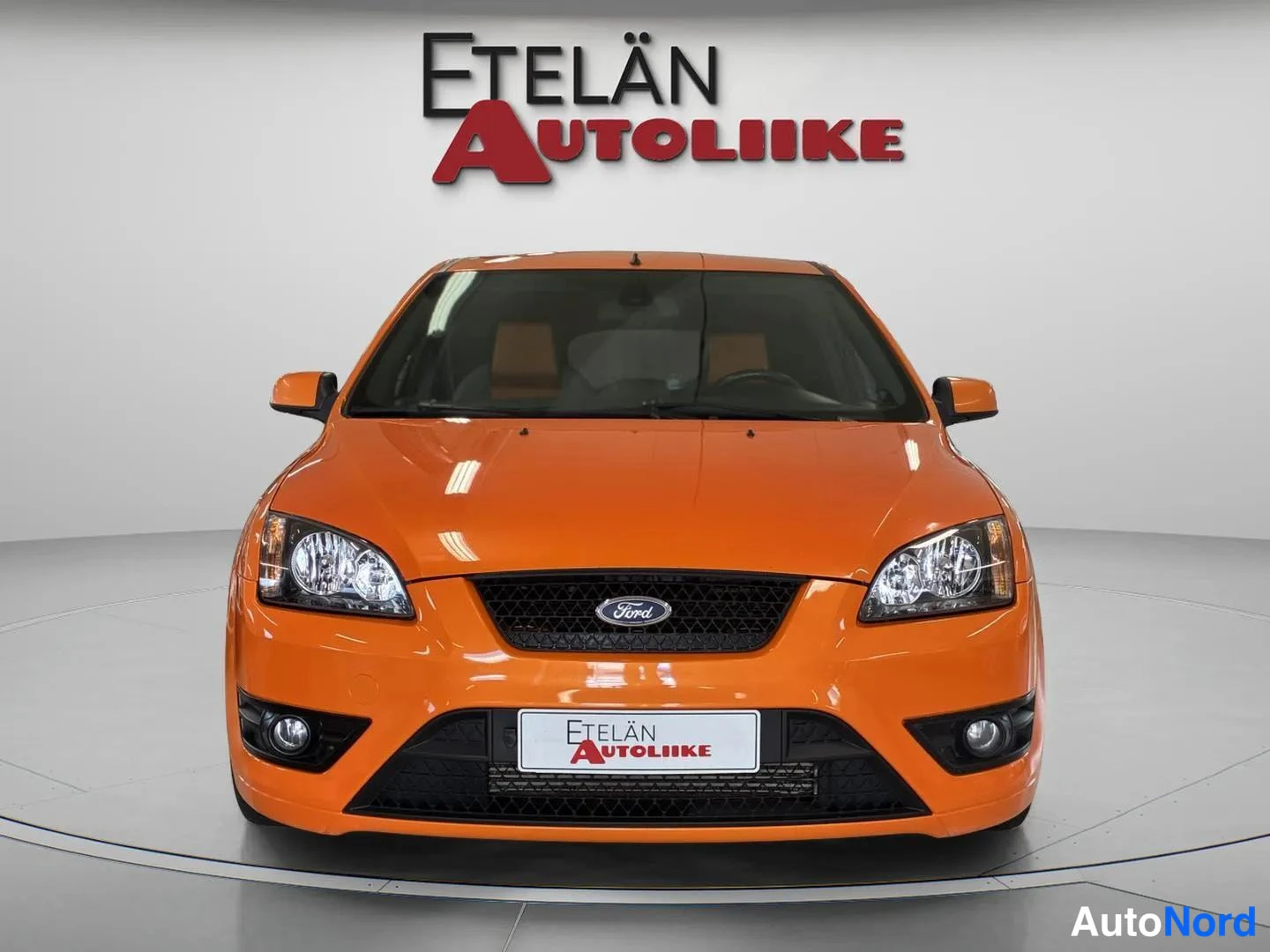 Edestä: Oranssin Ford-kolmioisen suorakaide kuva studiosta, kuvassa näkyvä edessä oleva logo ja Etelän Autoliike-tunnus.