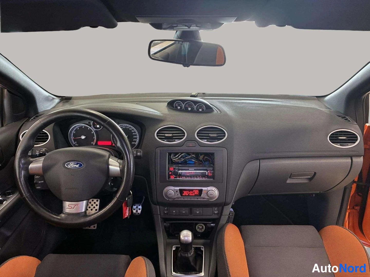 Sivulta: Näkymä auton sisätiloihin tuulilasin suunnasta: Ford-ohjauspyörä ST-merkinnällä, audiojärjestelmä keskikonsolissa ja kolme lisämittaria kojelaudan yläosassa.