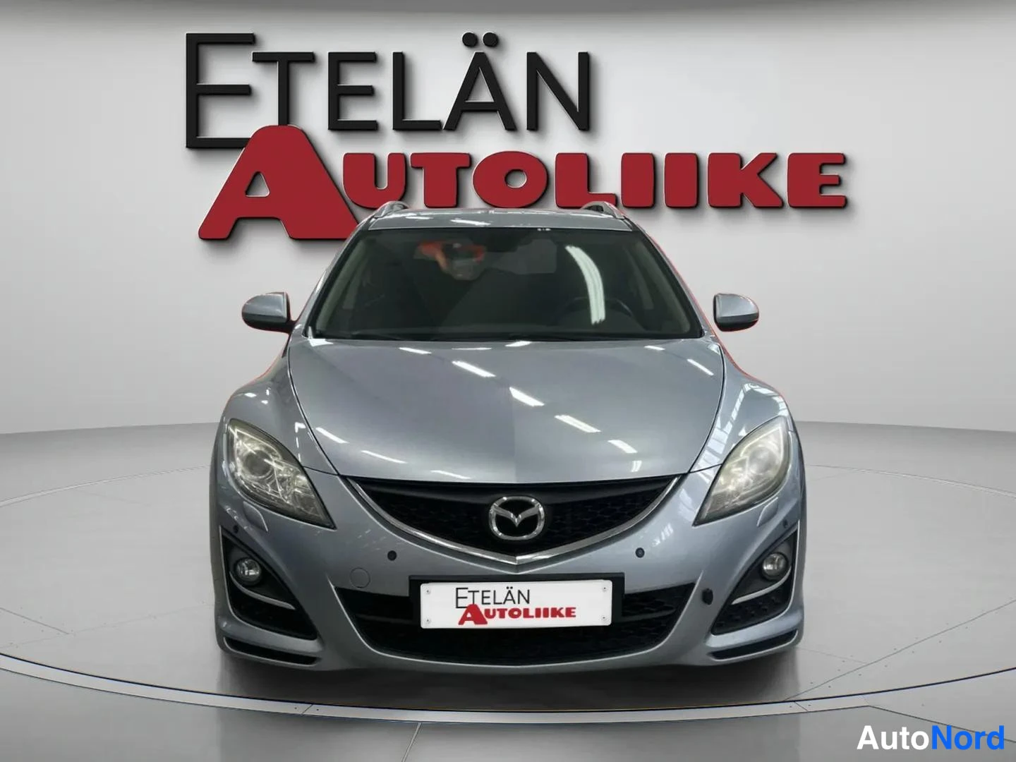 Edestä: Auton etupää suoraan edestä, sälekaittotakki kylkiauki, Etelän Autoliike -kyltti rekisterin paikalla.