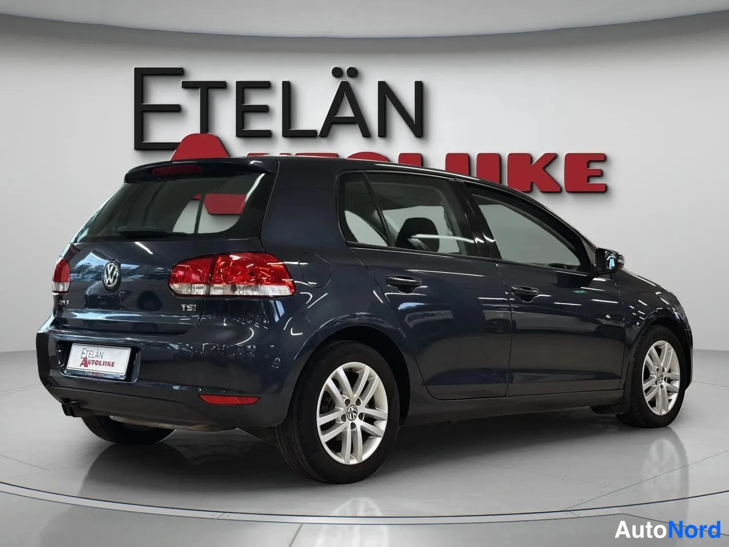 Takaviisto: Tummansininen Volkswagen Golf takaviistosta vasemmalta kuvattuna, takavalo, TSI-merkintä ja kylki näkyvät.