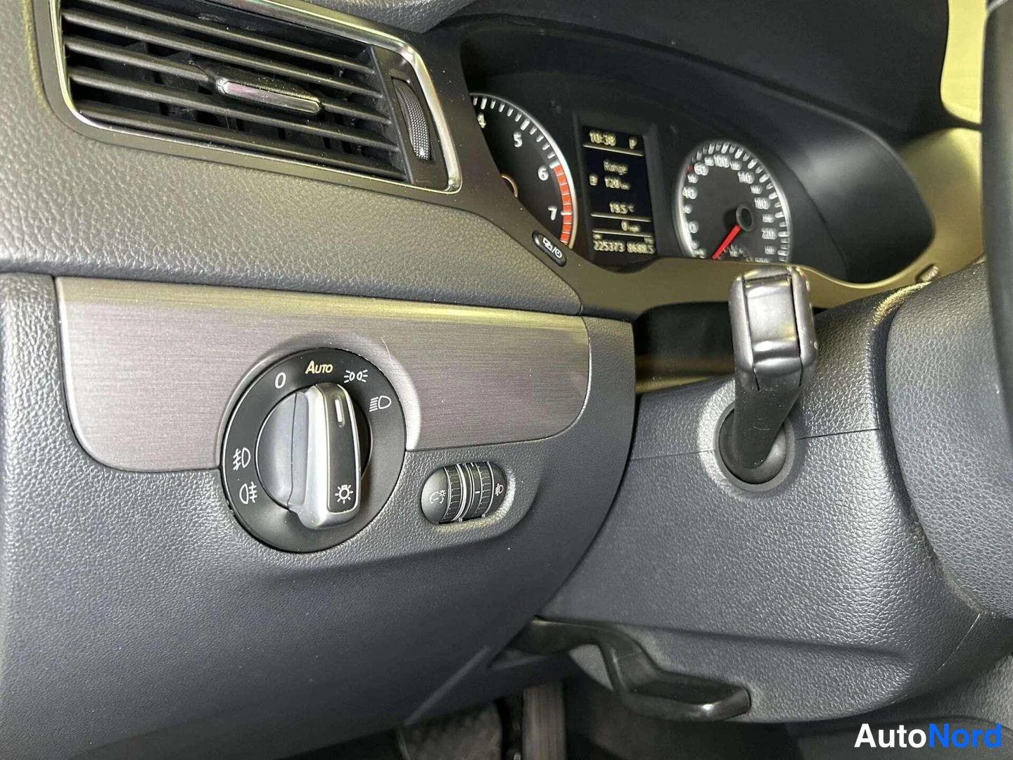 Muu: Driver's dashboard detail showing an exterior light control dial to the left of the instrument cluster. The dial includes settings marked '0', 'Auto', parking l