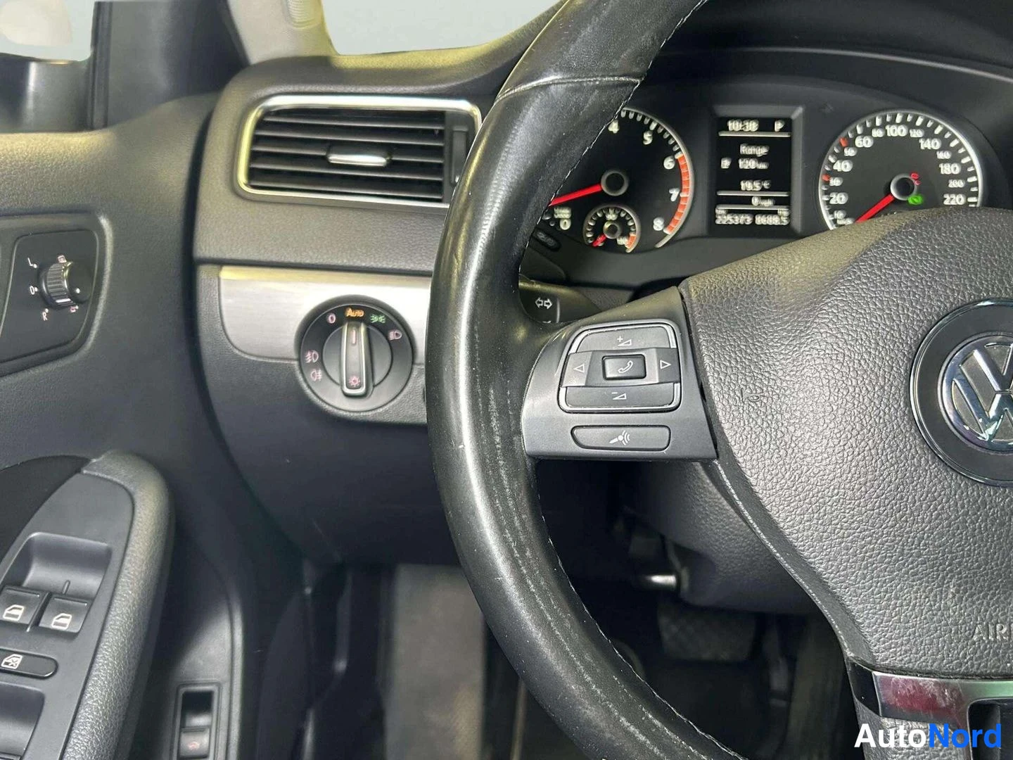 Etuistuimet: Steering wheel from the driver's perspective. A multifunction control pad is mounted on the left spoke featuring buttons for phone call functions and volume/tra
