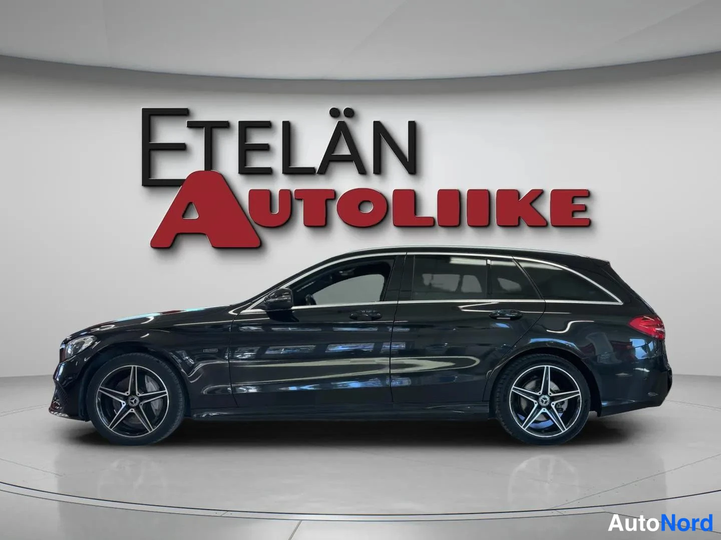 Sivulta: Musta Mercedes-Benz farmari sivuprofiilissa keula vasemmalla: kevytmetallivanteet, kattokiskot ja tummat ikkunat näkyvät.