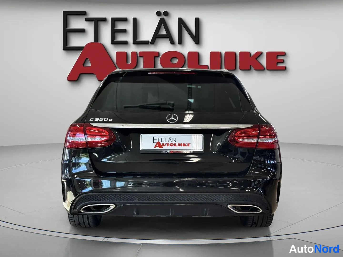 Takaa: Auton takaosa suoraan takaa; mustan farmariauton takaluukussa C 350 e -teksti, kaksi pakoputkea.