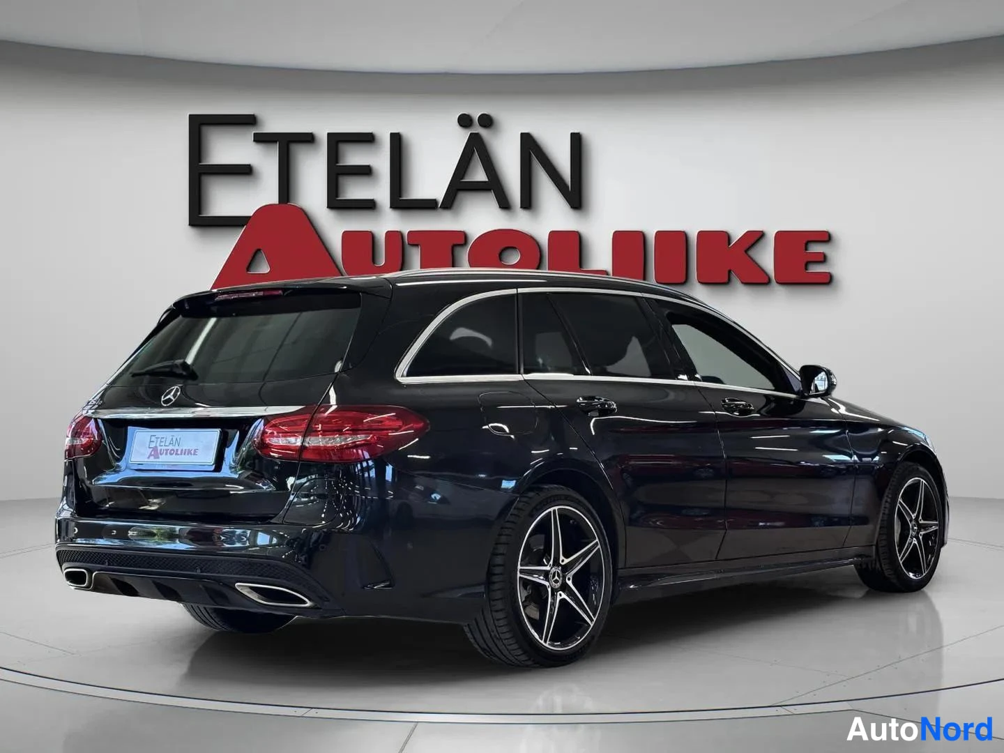 Takaviisto: Auton takaosa ja vasen sivu; musta Mercedes-Benz -farmari takahaara kulmassa, takaosa ja kylki näkyvät.