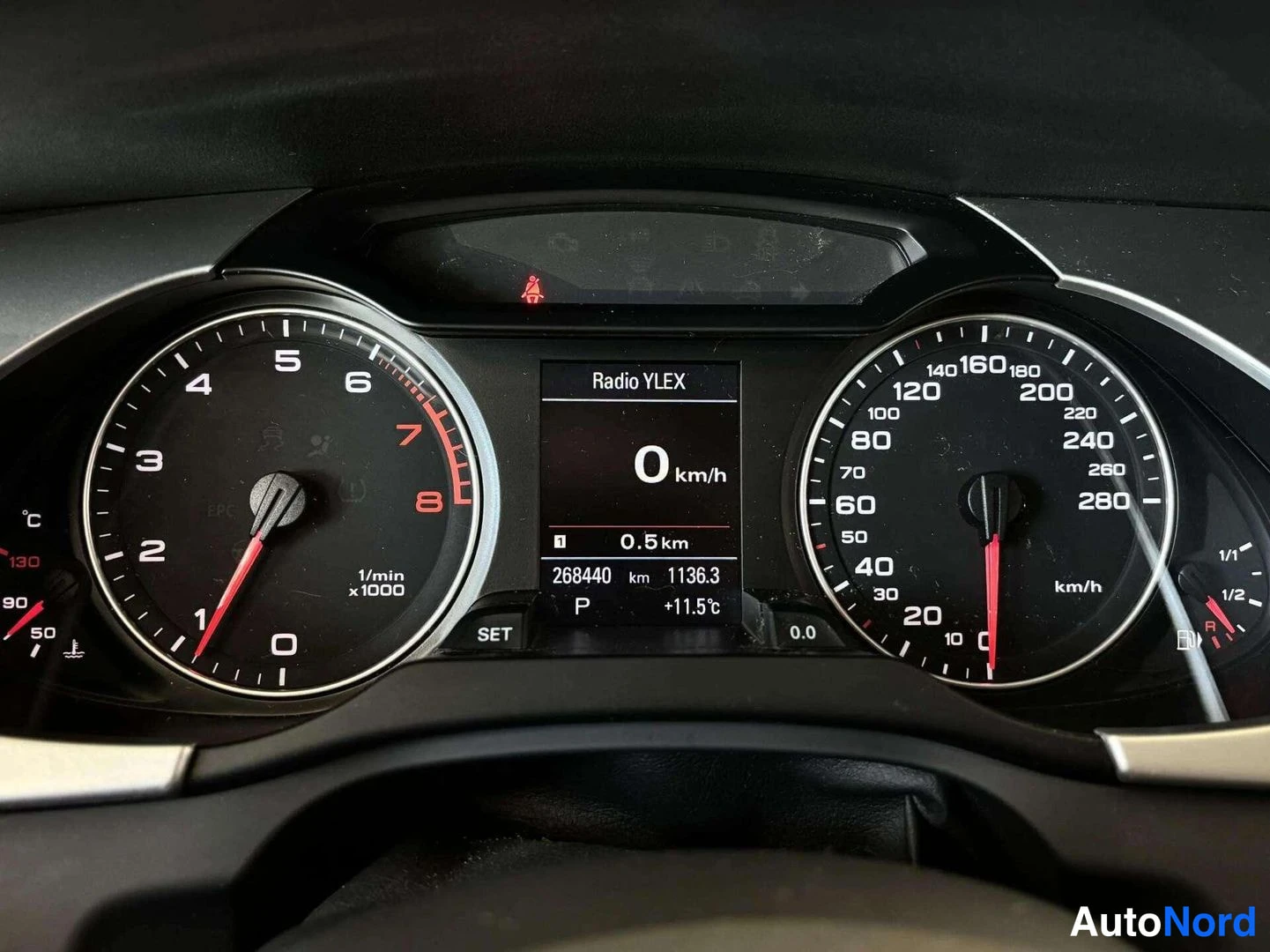 Muu: Audi A4:in mittaristo: nopeusmittari asteikolla 0–280 km/h, kierrosmittari 0–8, näytössä Radio YLEX, matkamittari 268440 km ja vaihde P.