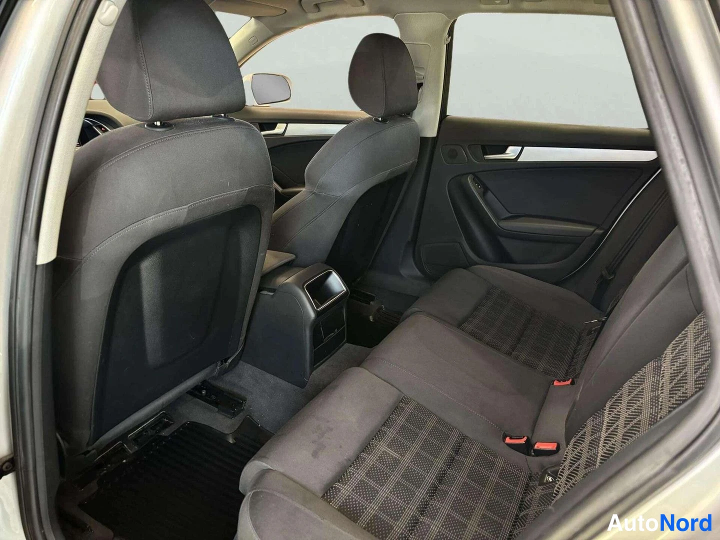 Muu: Audi A4:n takapenkkien ja etuistuinten selkänojat kankaaverhoilulla, takapenkin toinen osa taitettuna, kuvattu takaoven aukosta.