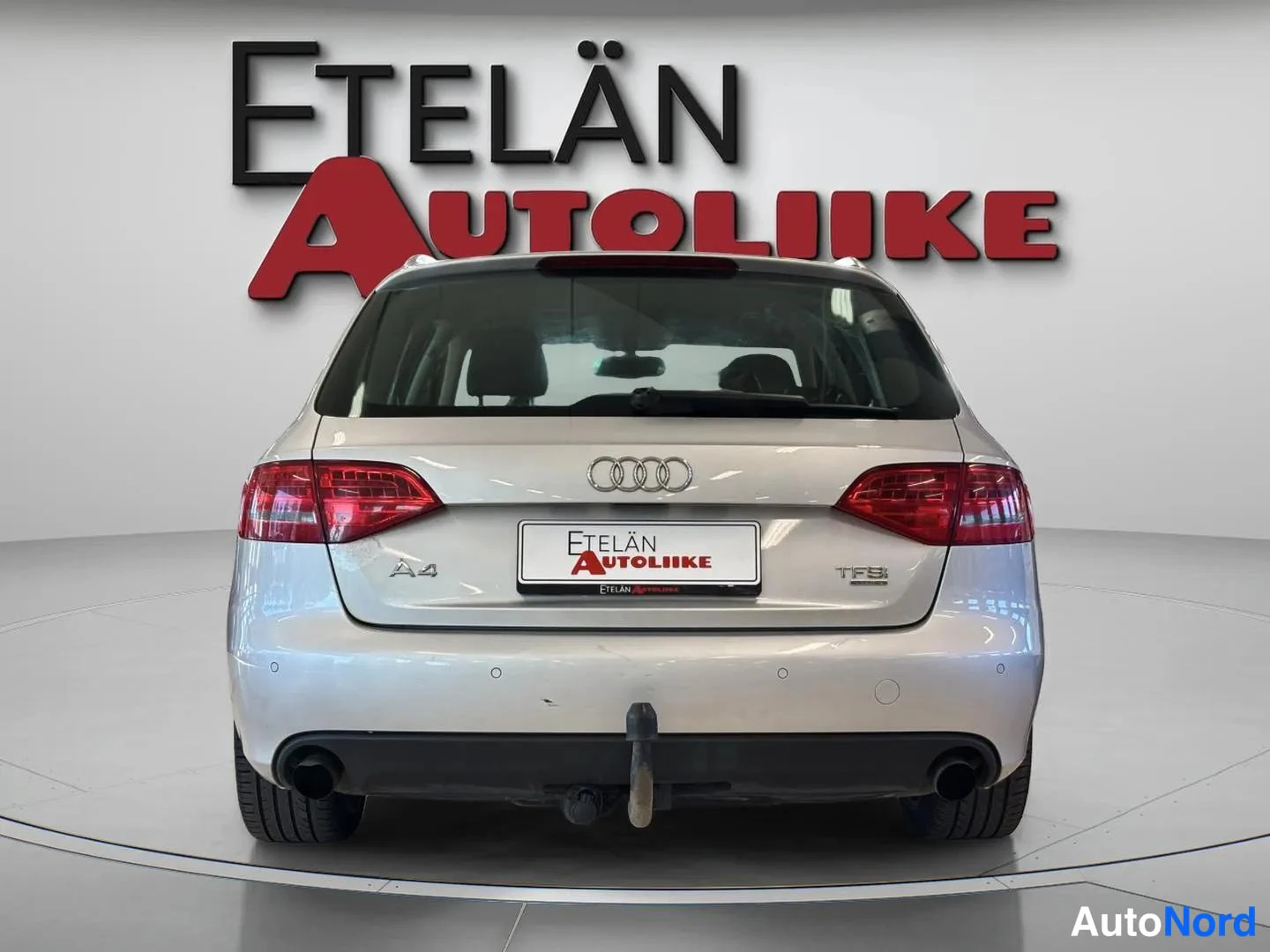 Takaa: Hopeanharmaa Audi A4 Avant suoraan takaa kuvattuna, A4- ja TFSI-merkit, Etelän Autoliike -rekisterikilpi ja taustatunnelma.