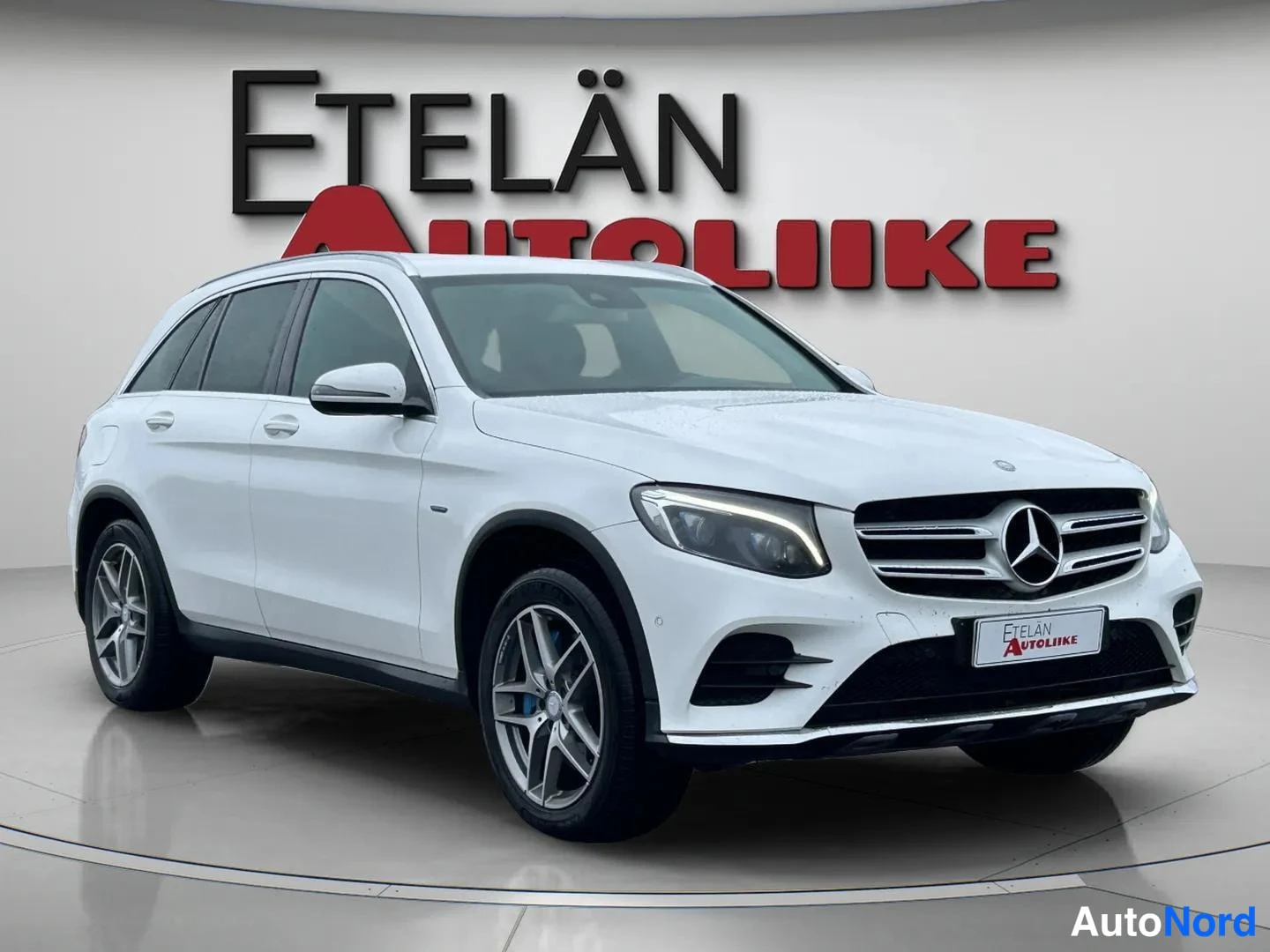 Etuviisto, nokka oikealle: Valkoinen Mercedes-Benz GLC -maasturi etuviistosta oikealta kuvattuna, Mercedes-tähti etusäleikössä, LED-päiväajovalot ja hopeiset kevytmetallivanteet.