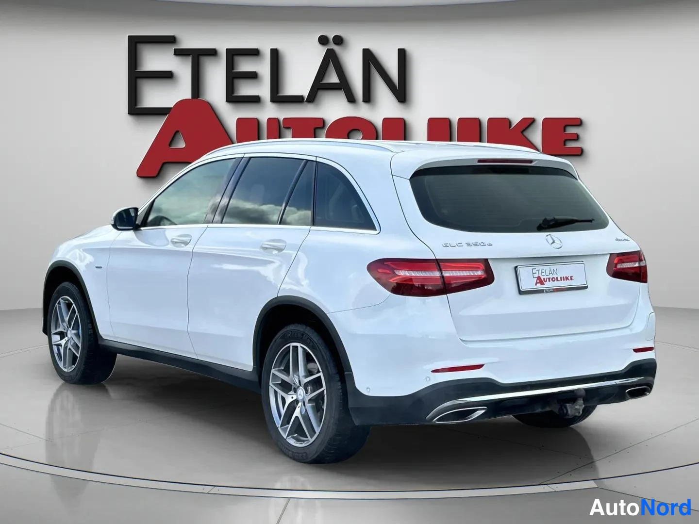 Takaviisto: Valkoinen Mercedes-Benz GLC takaviistosta vasemmalta kuvattuna, punaiset takavalot, takaapuiskija ja kaksiosaiset pakoputket näkyvät; takaluukussa teksti GLC 35