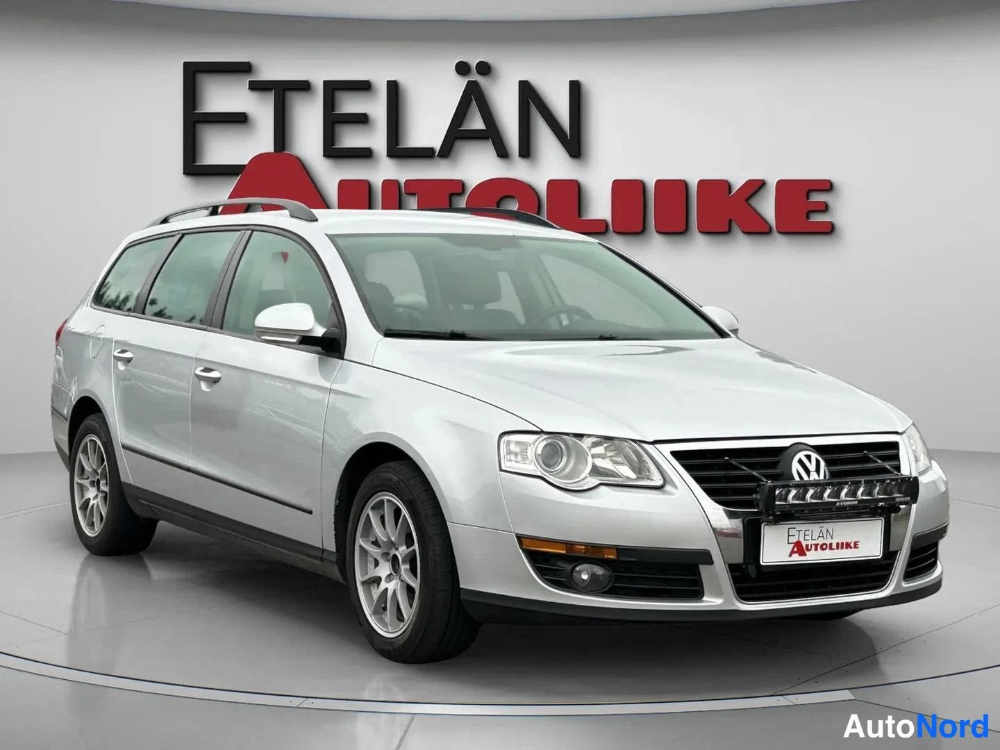 Etuviisto, nokka oikealle: Hopeanvärinen Volkswagen Passat -farmari kolmesta neljäsosan etunäkymästä, keulakko oikealla.