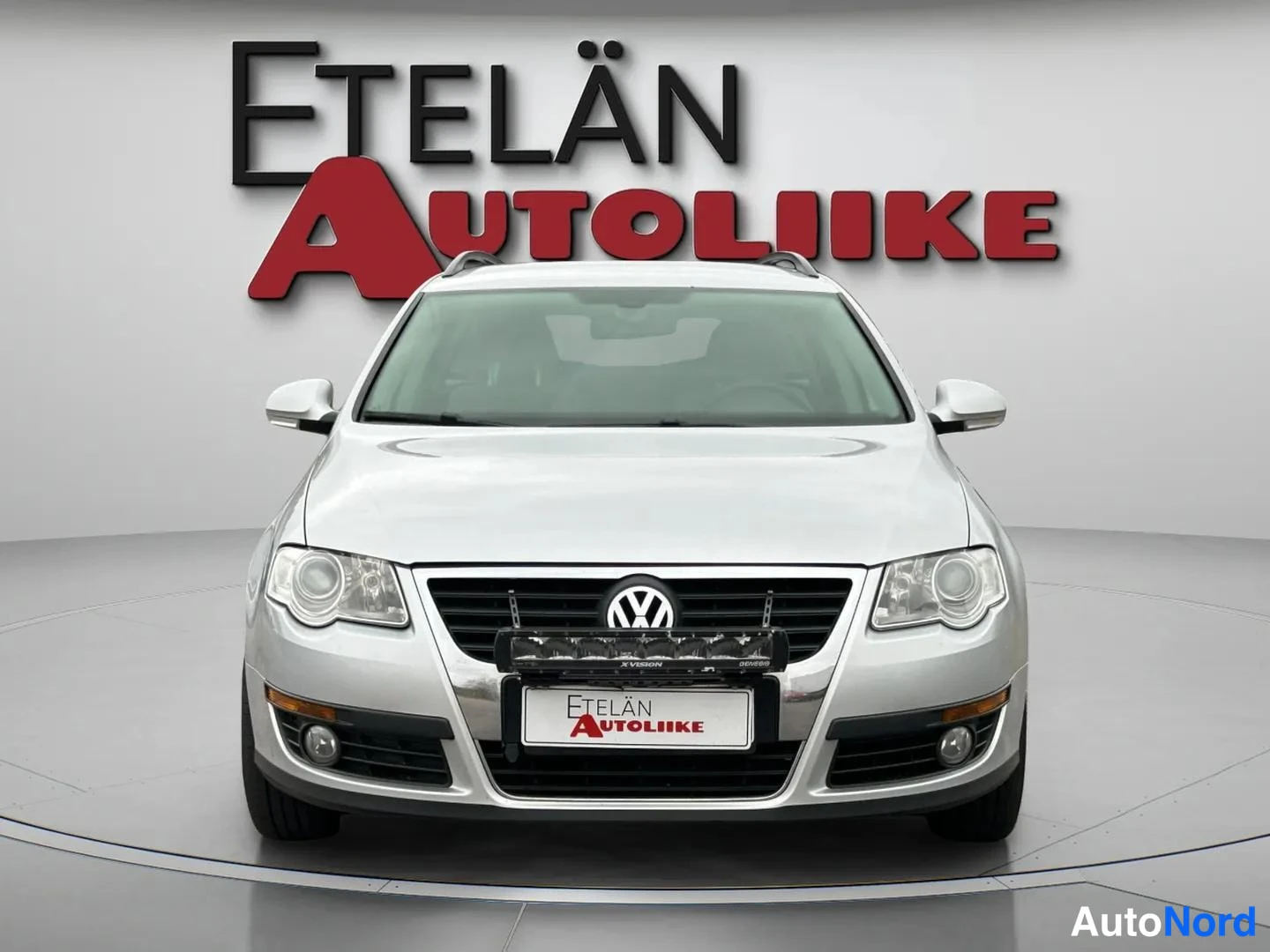 Edestä: Hopeanvärinen Volkswagen Passat -farmari suoraan edestä kuvattuna.