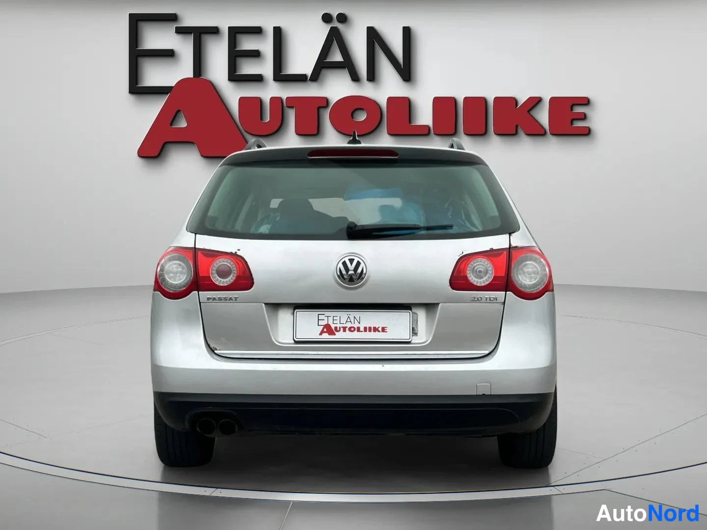 Takaa: Hopeanvärinen farmariauto suoraan takaa, takavalot, VW-merkki ja Etelän Autoliike-rekisterikilven suojus näkyvät.