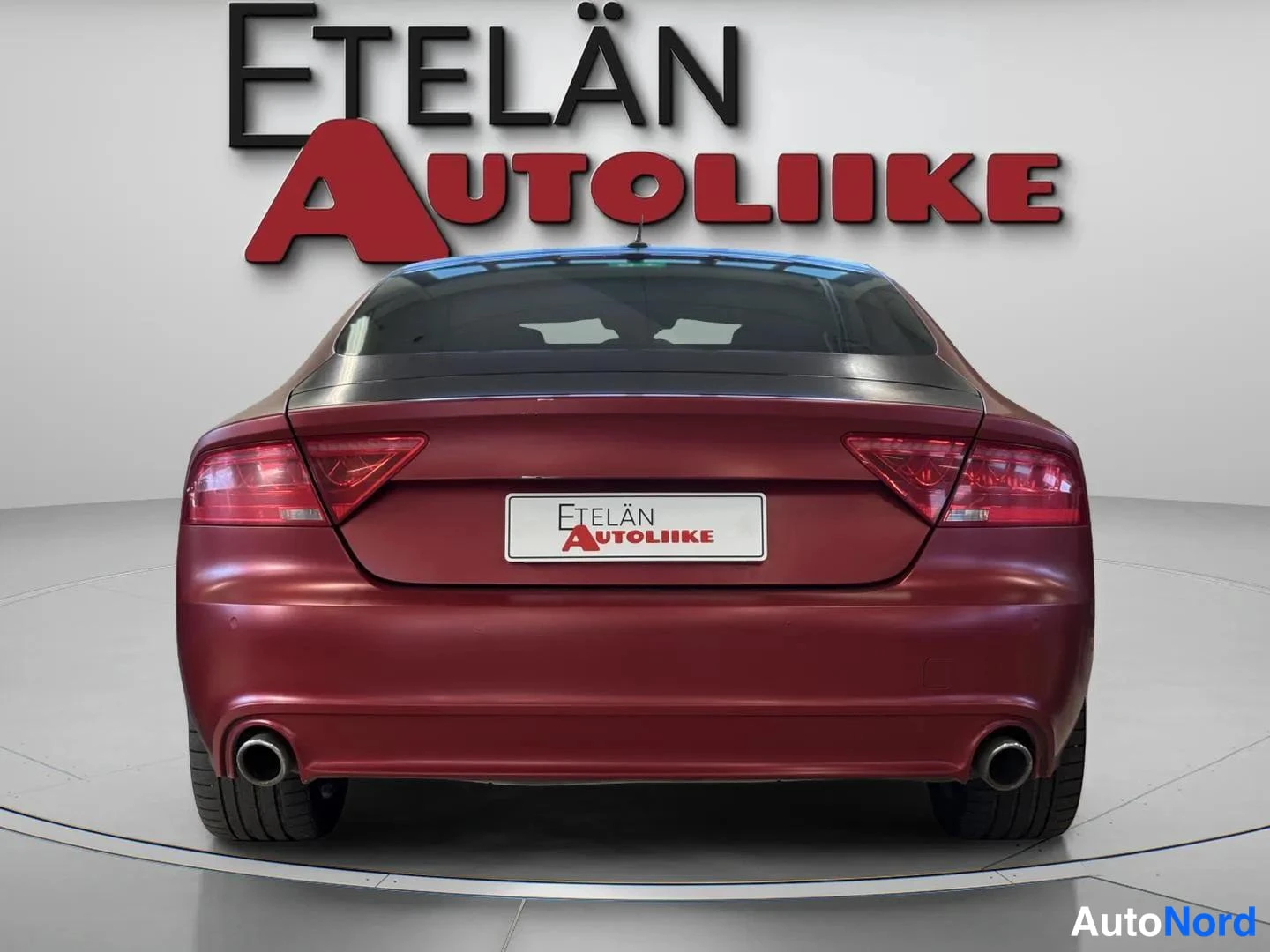 Takaa: Audi A7 Sportbackin takaosan suora taka suicides, korin väri tummanpunainen, kaksipaikkaiset pakoputket näkyvät puskurissa. Autoliike Etelän Autoliike -logo tau