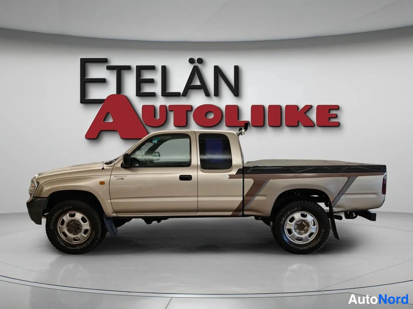Sivulta: Beige avolava-auto sivulta kuvattuna showroomissa.