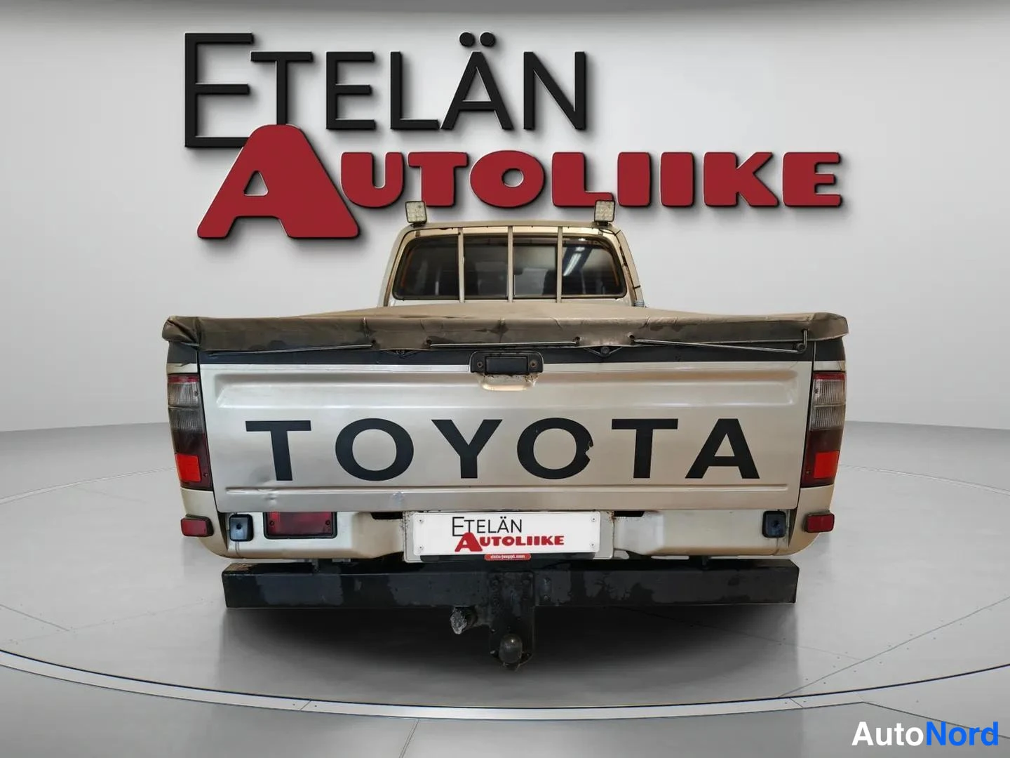 Takaa: Auton takaosa suoraan takaa, TOYOTA-teksti lavan takapaneelissa.