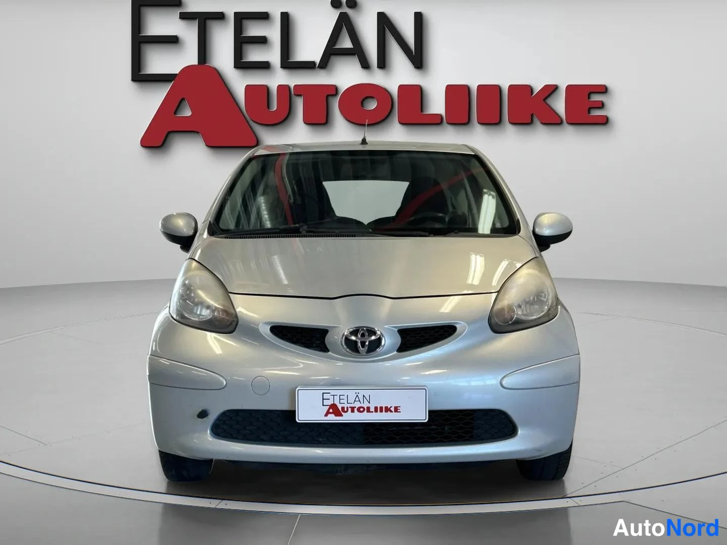 Edestä: Direct frontal view of a silver two-door Toyota Aygo.