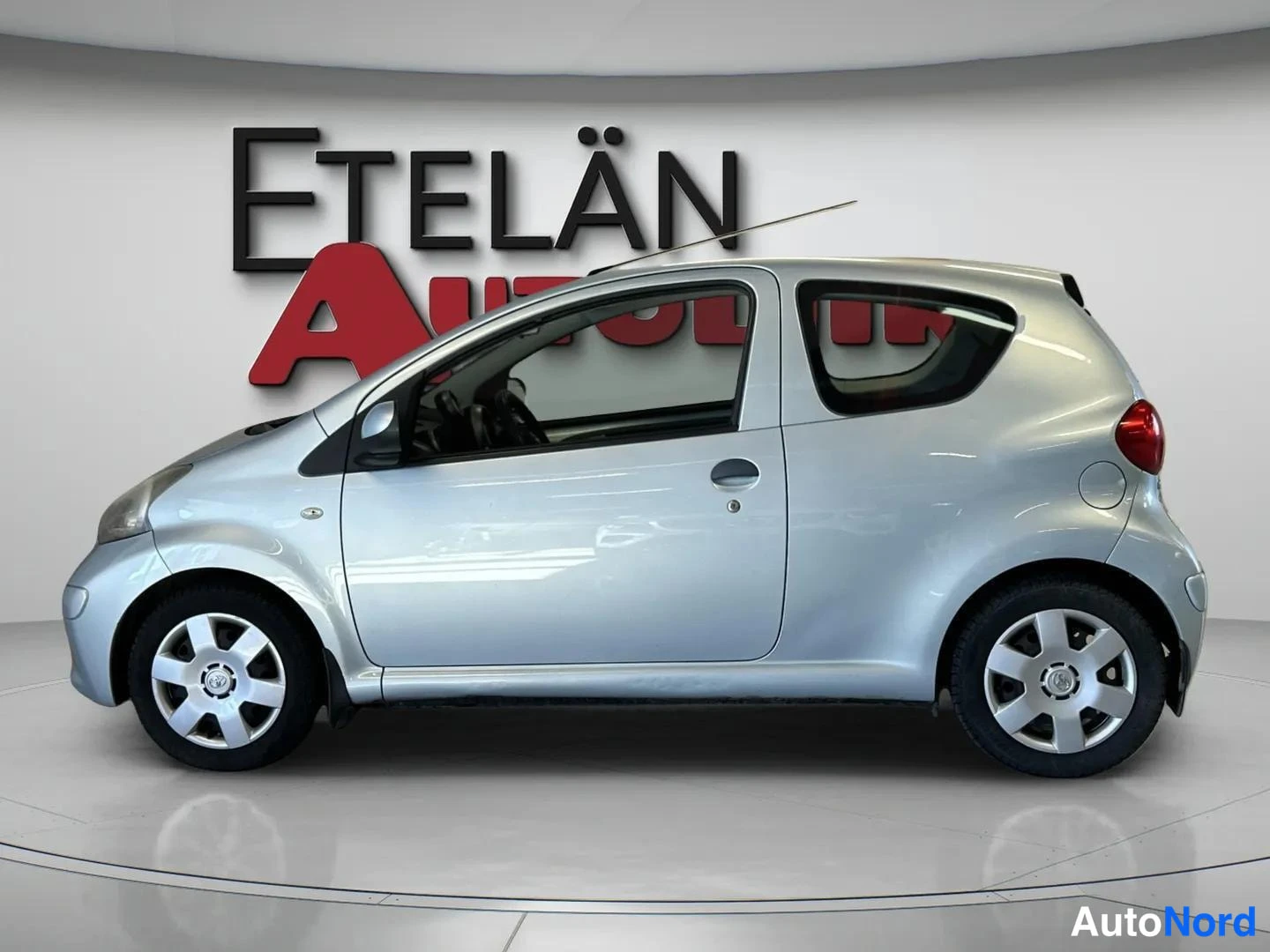 Sivulta: Side profile view of a silver two-door Toyota Aygo.