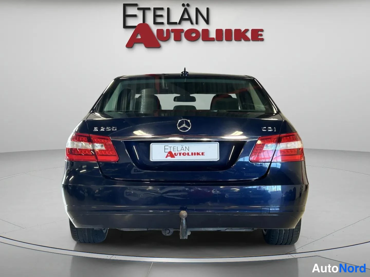 Takaa: Auton takapää suoraan edestä kuvattuna studiossa; kannessa Mercedes-tähti, mallimerkinnät ja jäljessä vetokoukku.