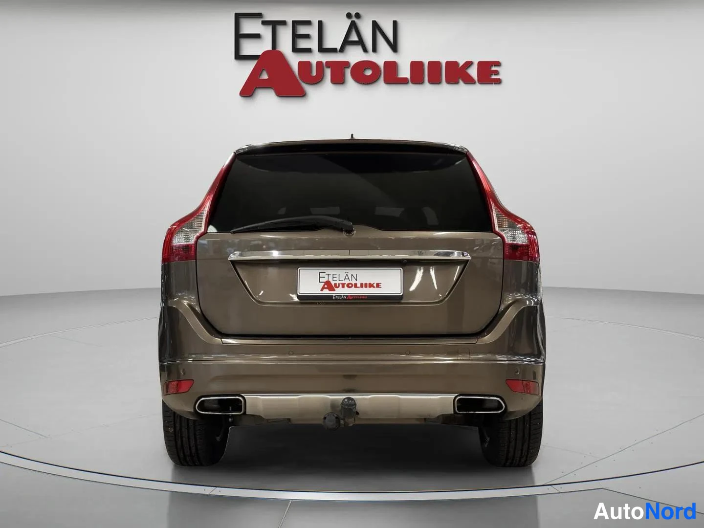 Takaa: Täysin takaa kuvattu ruskea automobiili, takavaloja, takaluukku ja takaamppia erottuu, valkoinen studio tausta.
