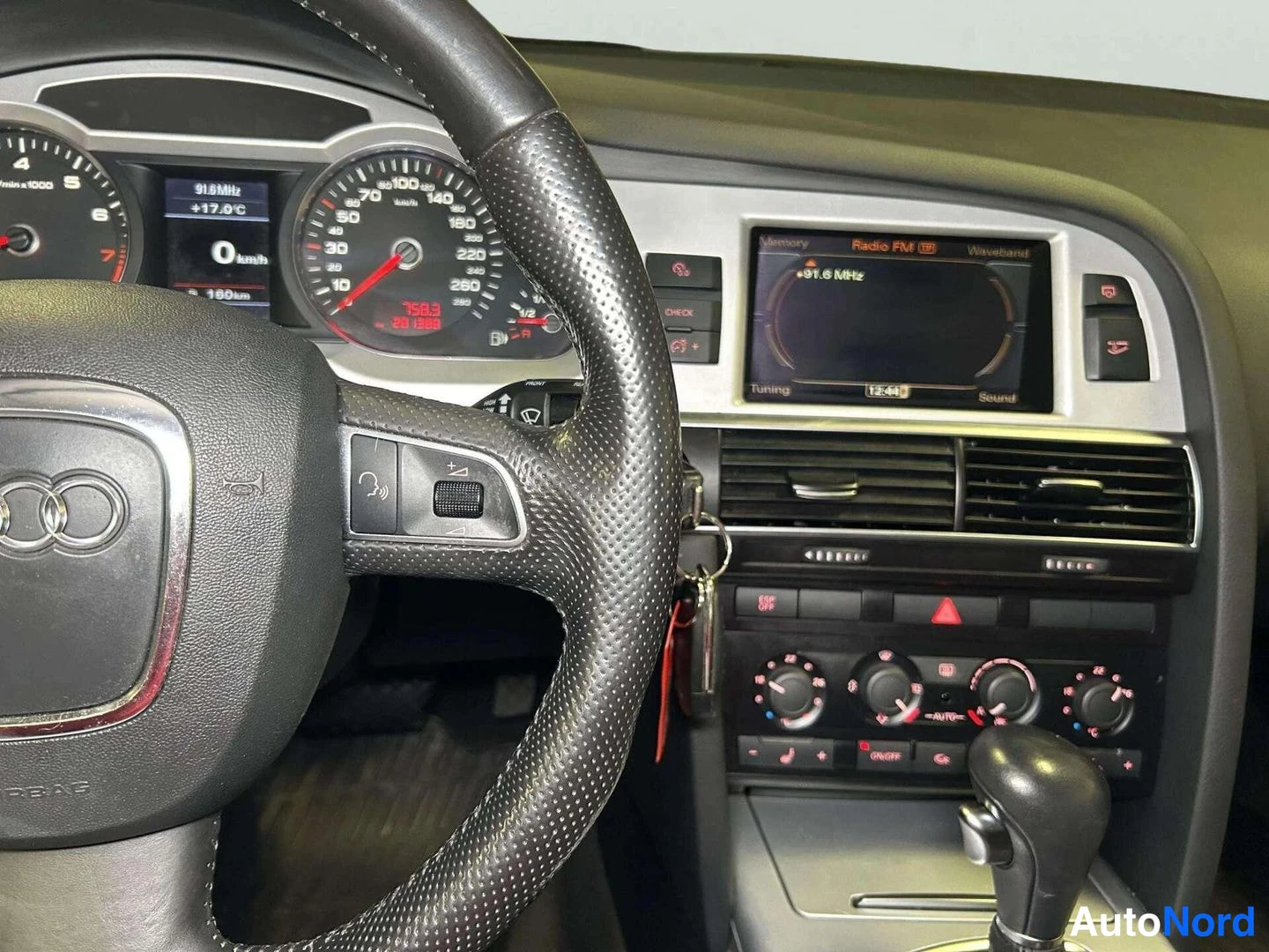 Muu: Audi A4:n kojelauta: mittaristo, radioikkuna (91,6 MHz, kello 12:45), ilmastointisäätimet ja automaattivaihteen vipu.