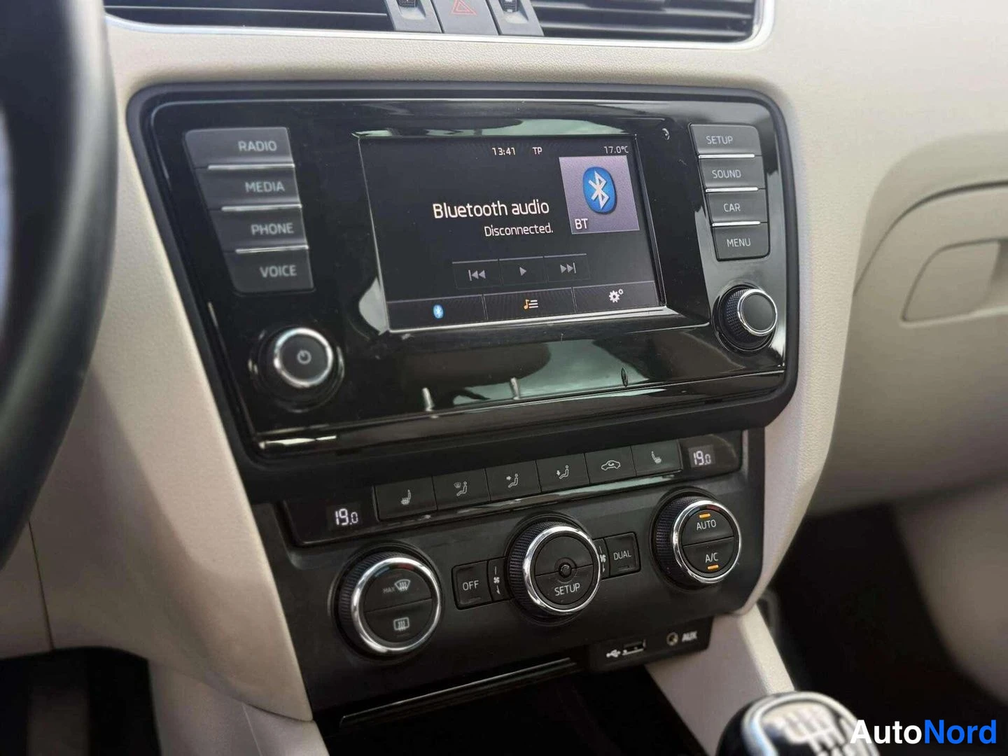 Edestä: Kojeiston keskiössä radiopaneeli, näytöllä teksti 'Bluetooth audio Disconnected.', alla kaksitoiminen ilmastointi (DUAL, A/C).