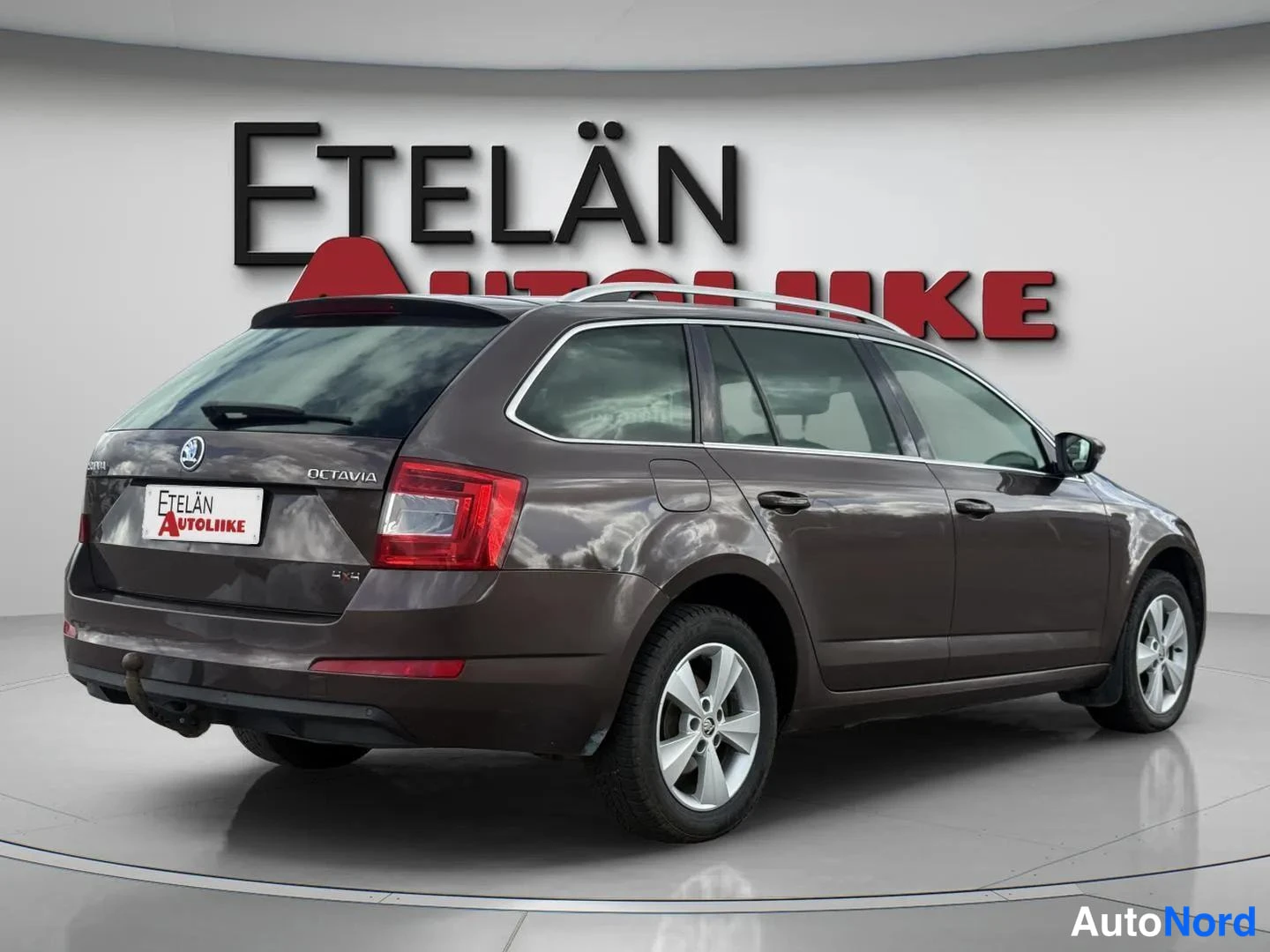Takaviisto: Skoda Octavia -farmarin takaosa viistosti vasemmalta, ruskeanharmaa kori.