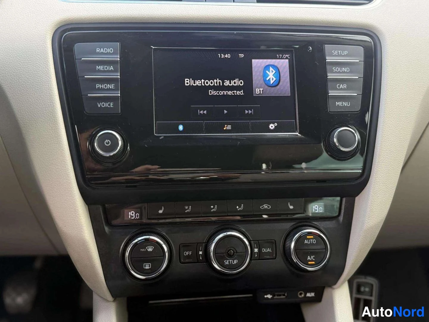 Yksityiskohta: Kojelaudan keskikonsoli: infotainment-näyttö näyttää tekstin 'Bluetooth audio Disconnected', ympärillä RADIO-, MEDIA-, PHONE- ja SETUP-painikkeet sekä automaatt