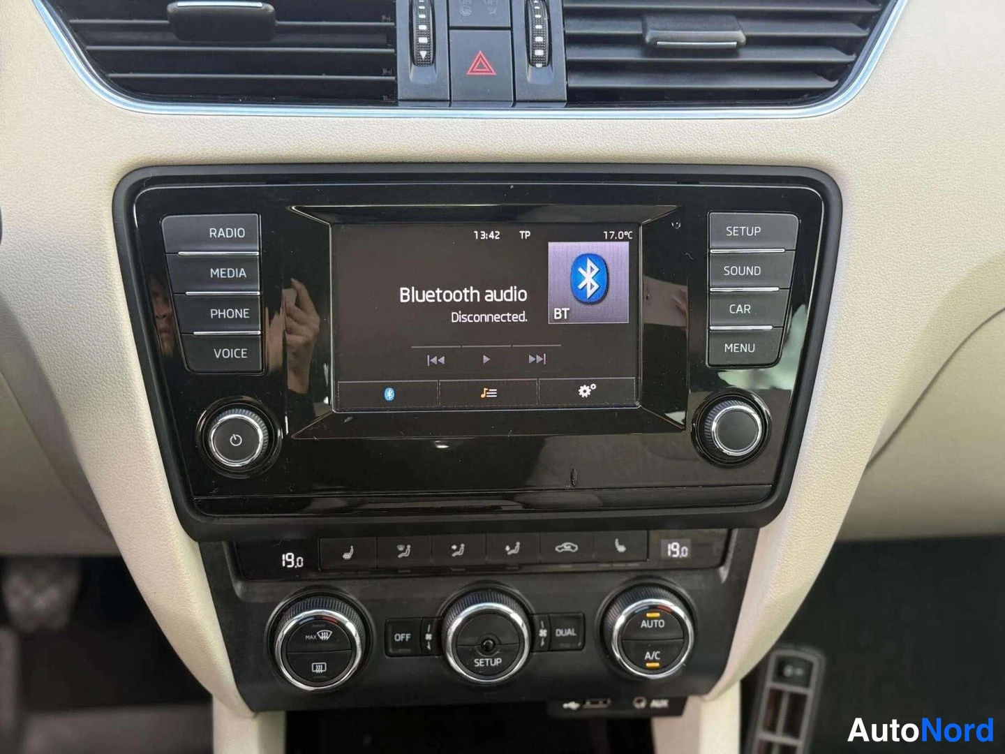 Yksityiskohta: Auton keskikonsoli suoraan edestä: näyttö näyttää 'Bluetooth audio Disconnected', alla kaksivyöhykeilmastoinnin säätimet (19,0 °C, AUTO, A/C, DUAL).