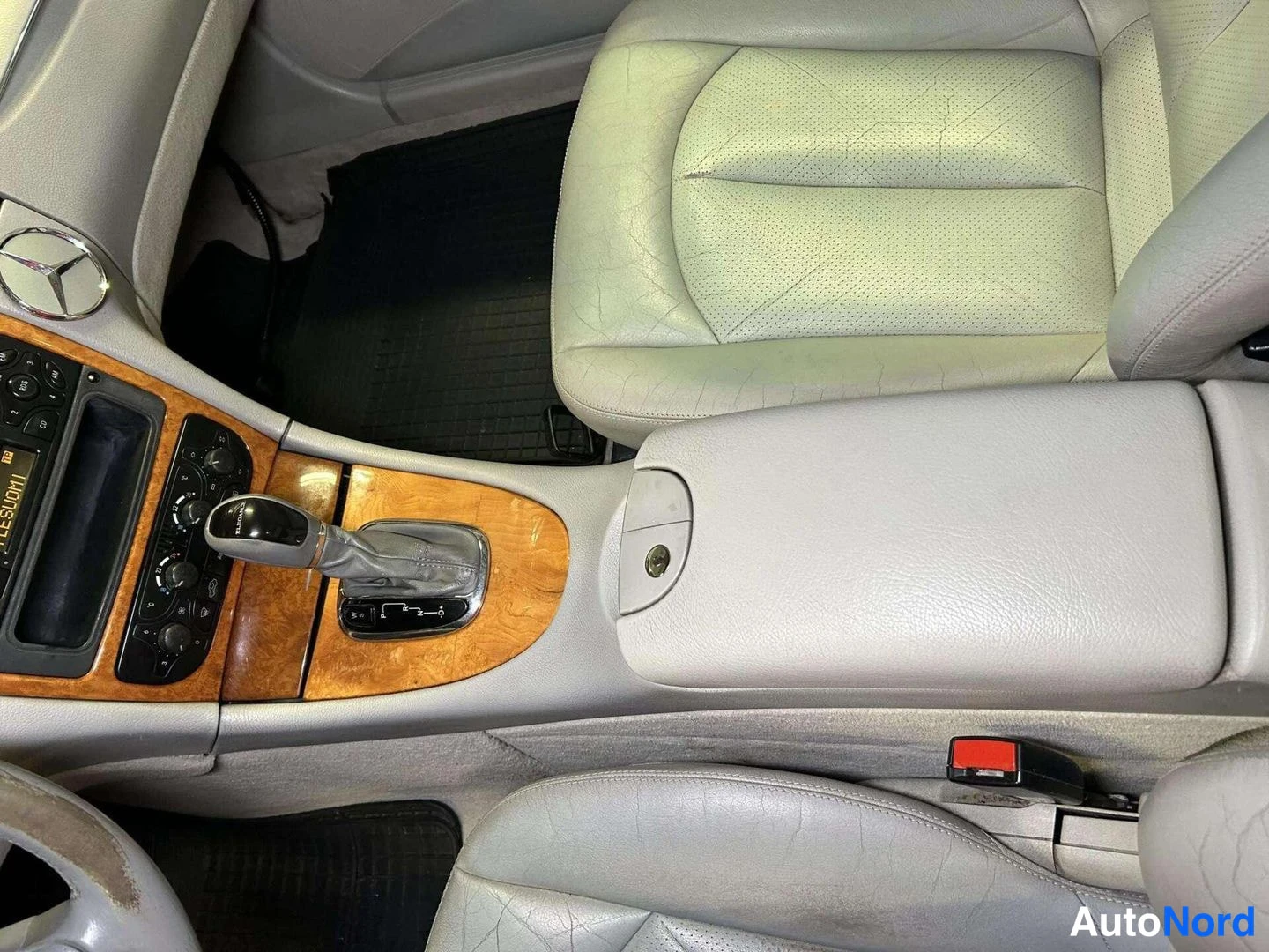 Muu: Vaaleat nahkaistuimet ja keskikonsoli vaihteenvalitsimella Mercedes-auton sisätiloissa.
