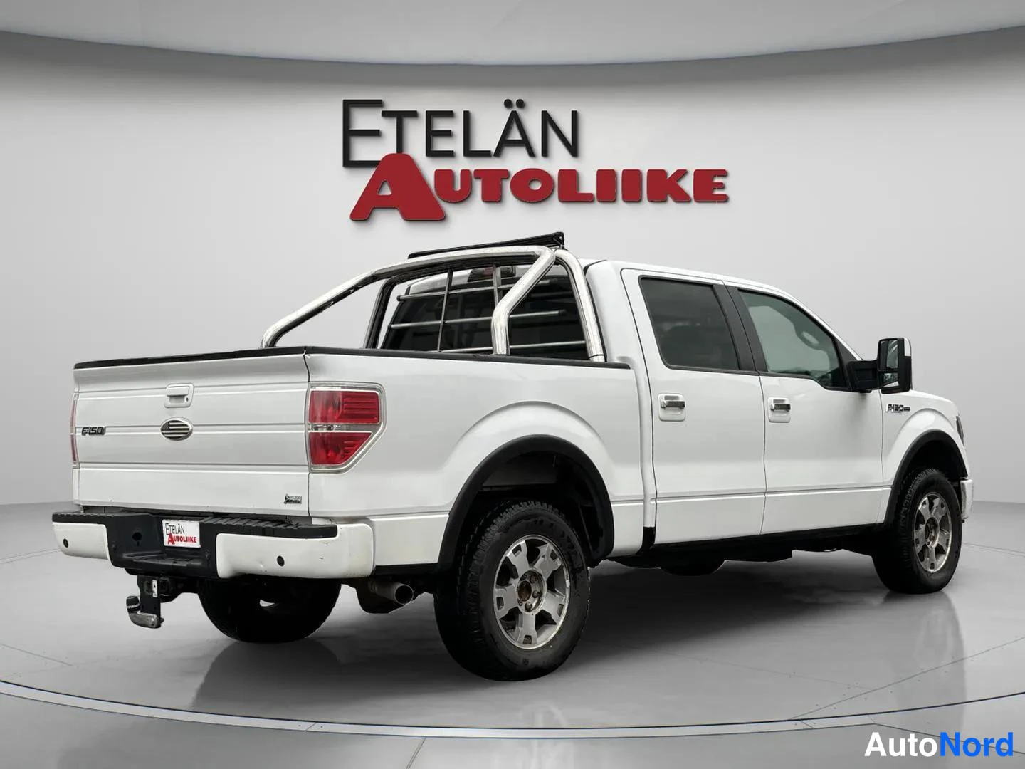 Takaviisto: Ford F-150 -pickup takaviistosta vasemmalta: valkoinen korirakenne, kromikaarituki lavan yllä ja neljä ovea näkyvissä.