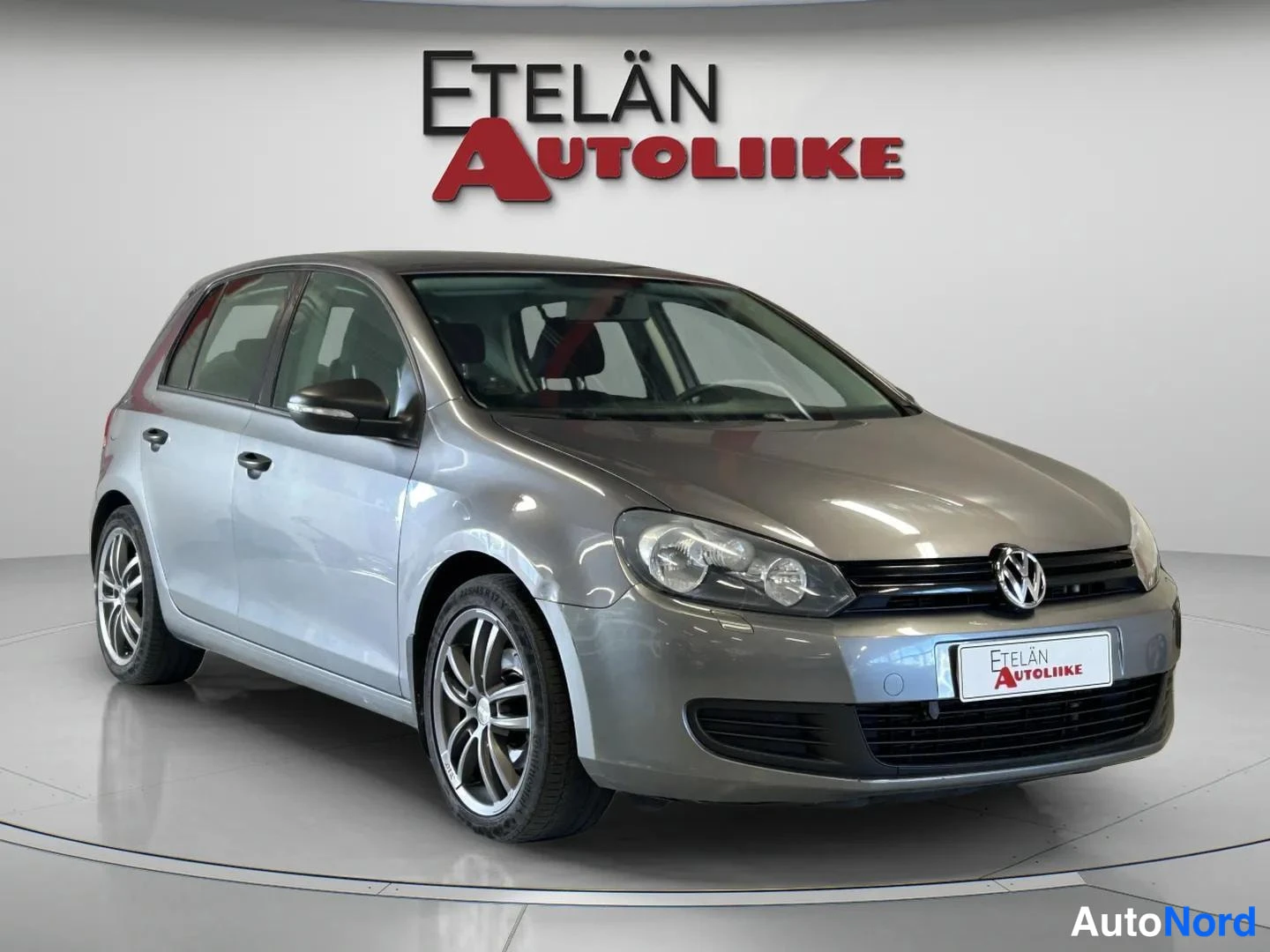 Etuviisto, nokka oikealle: Volkswagen Golf 2011, etunurkkakuva oikealta, harmaa viistoperä henkilöauto studiotaalustossa.