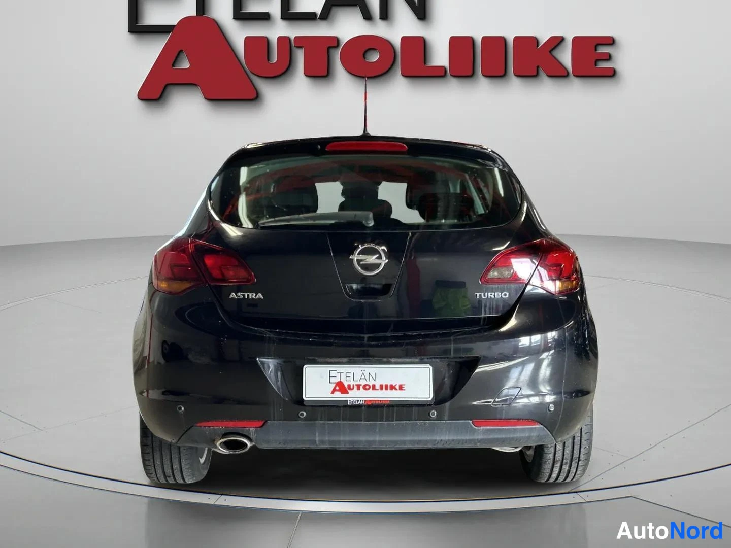 Takaa: Mustan farmarin takanäkymä: Opel Astra Turbo -merkinnät ja takavalot